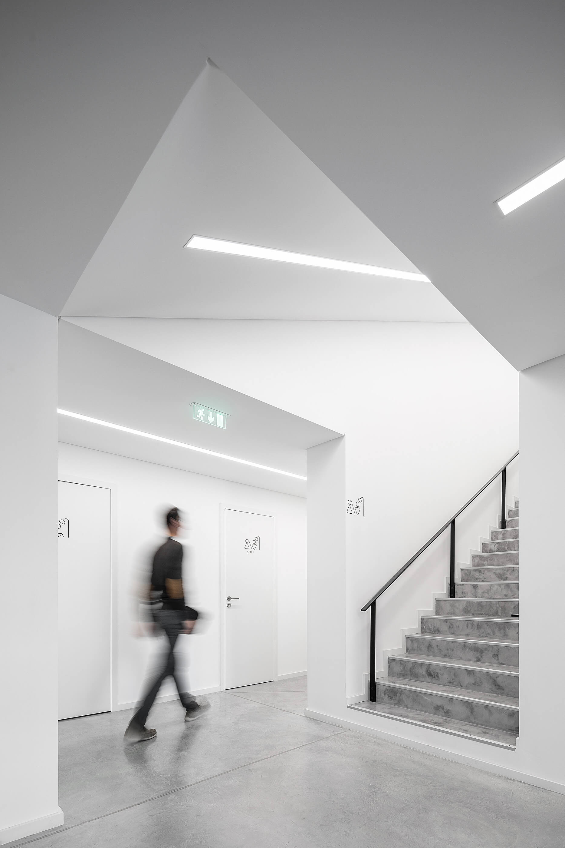 Corredor com portas brancas, escadas de betão e iluminação linear. Design minimalista e moderno. — Academia20 arquitetura StudioWorkers em Espinho
