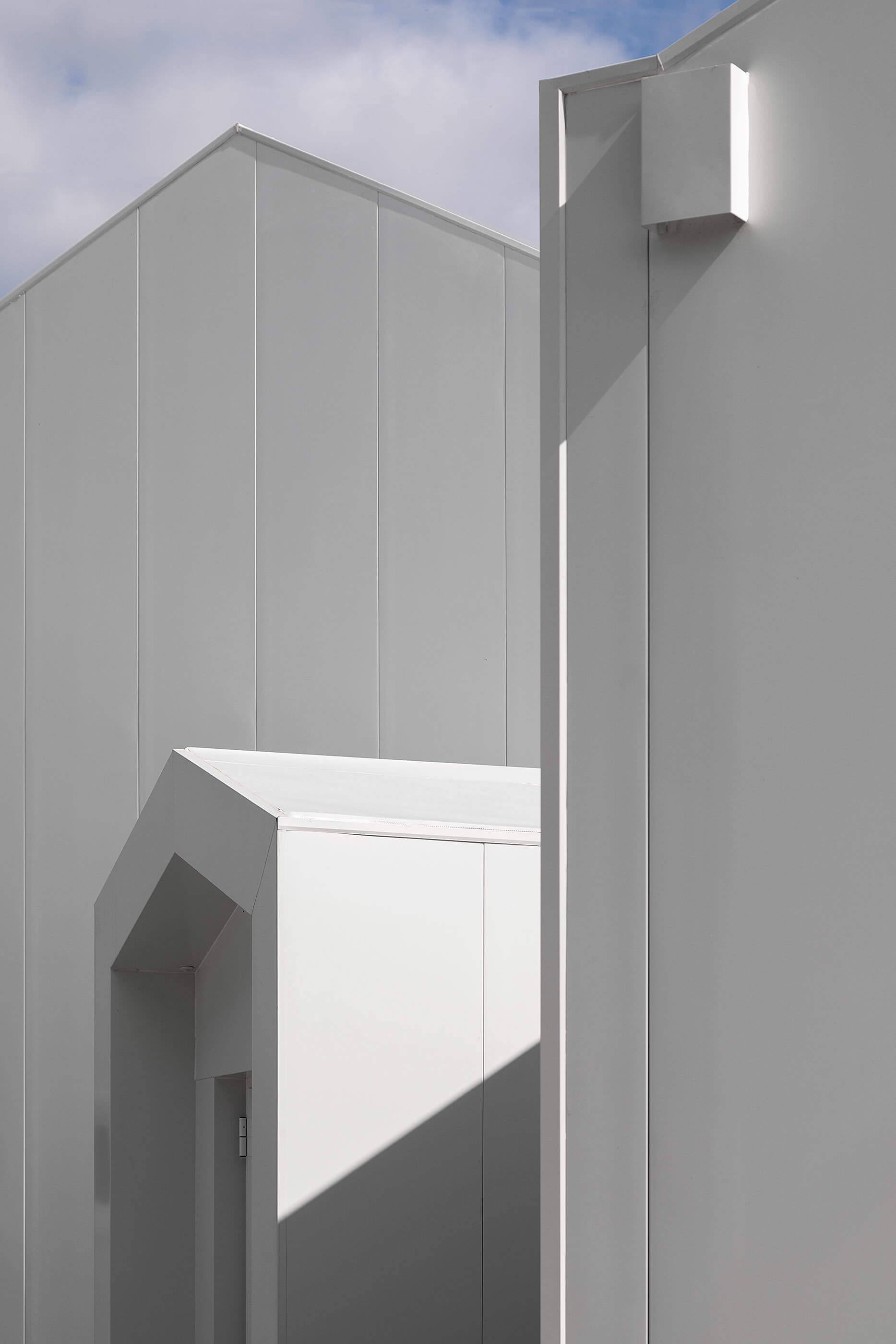 Detalhe da fachada branca com diferentes volumes e sombras geométricas. — Adega do Castanheirinho arquitetura João Albano Arquitecto em Águeda