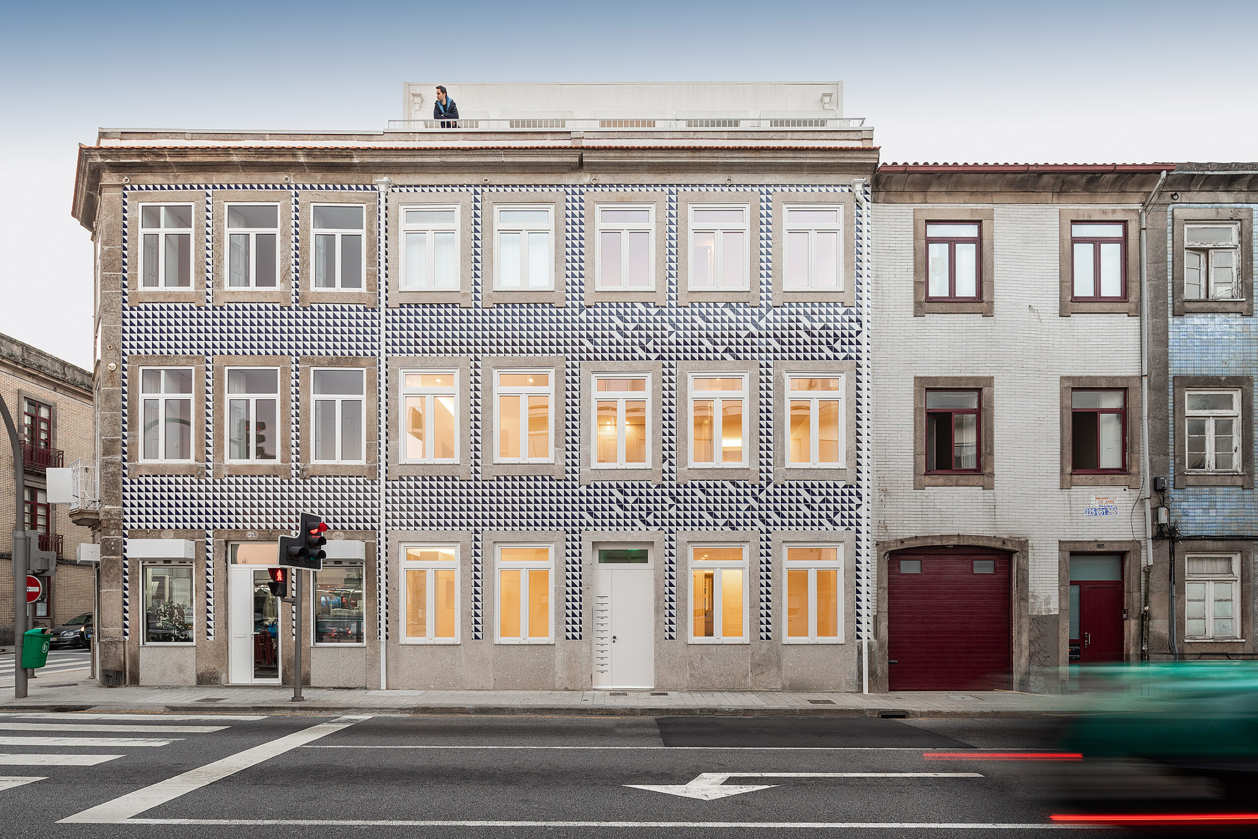 Edifício multifamiliar com fachada revestida a azulejos azuis e brancos, integrado na paisagem urbana do Porto. — Edifício Multifamiliar Alegria arquitetura MiMool Arquitectura & Interiores em Porto