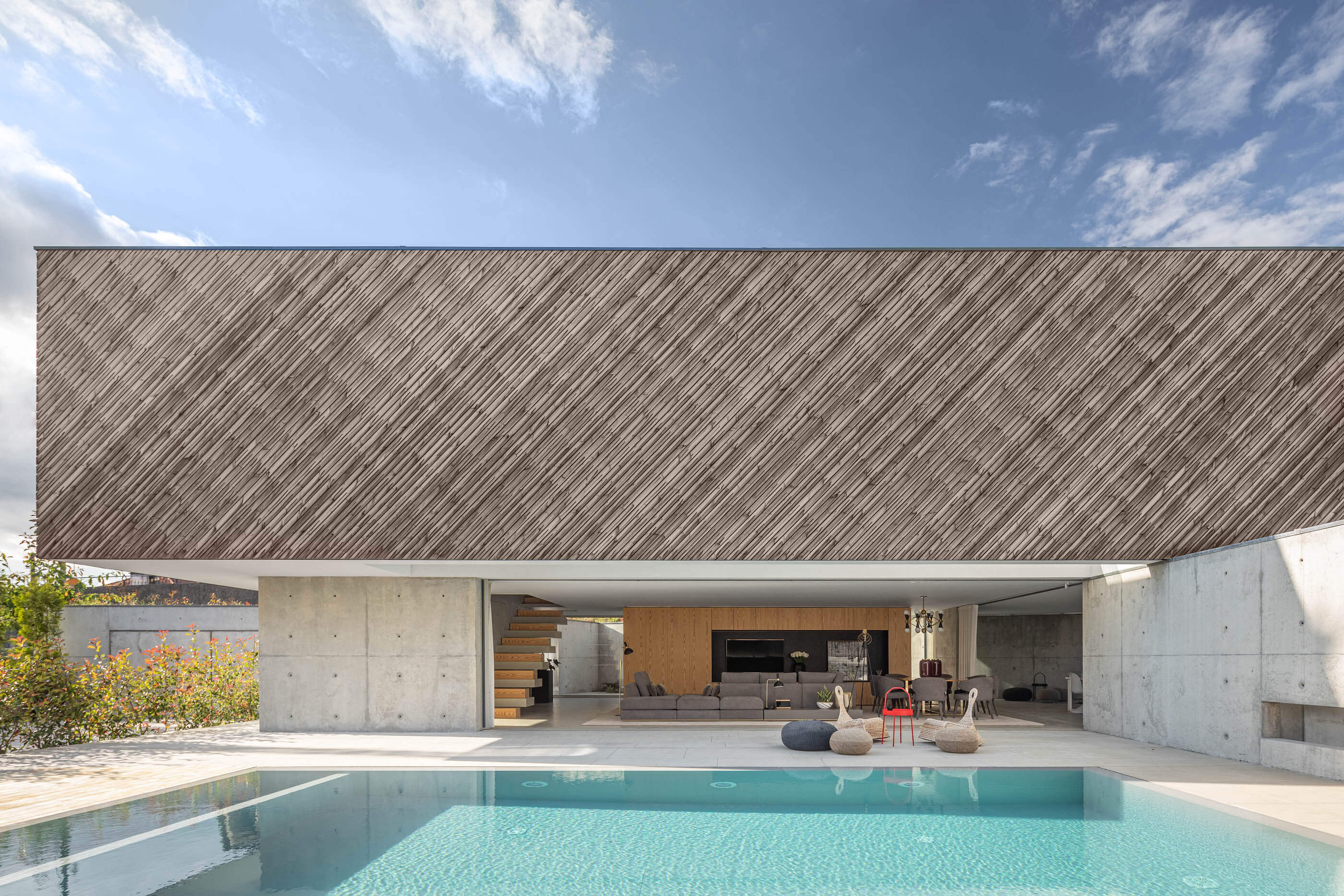 Vista exterior da Casa A com piscina, fachada em madeira e janelas envidraçadas. — Casa A arquitetura REM'A Arquitectos em Portugal