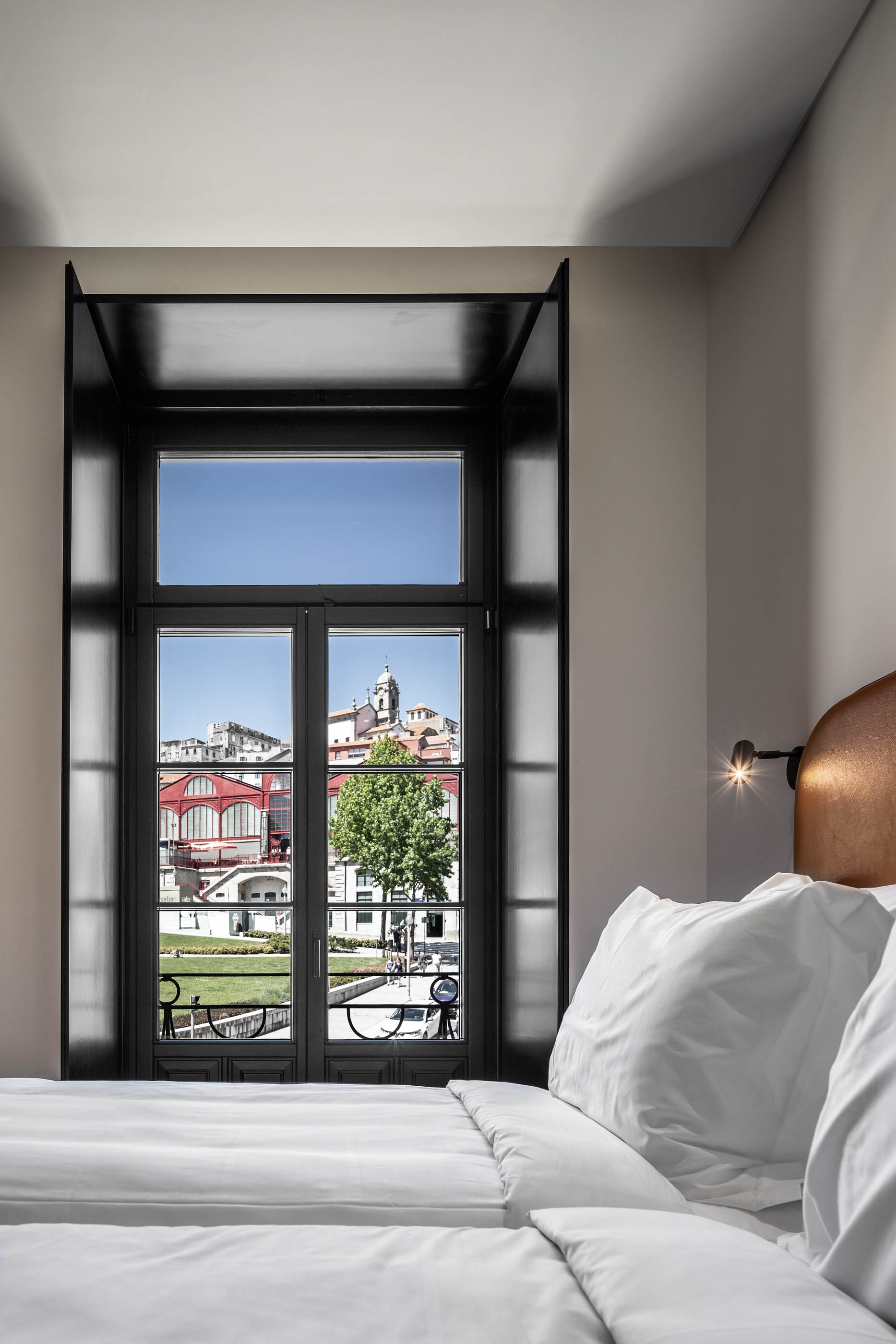 Vista da janela do quarto para a cidade do Porto, com edifícios históricos e luz natural. — Exmo Hotel arquitetura Floret Arquitectura em Porto