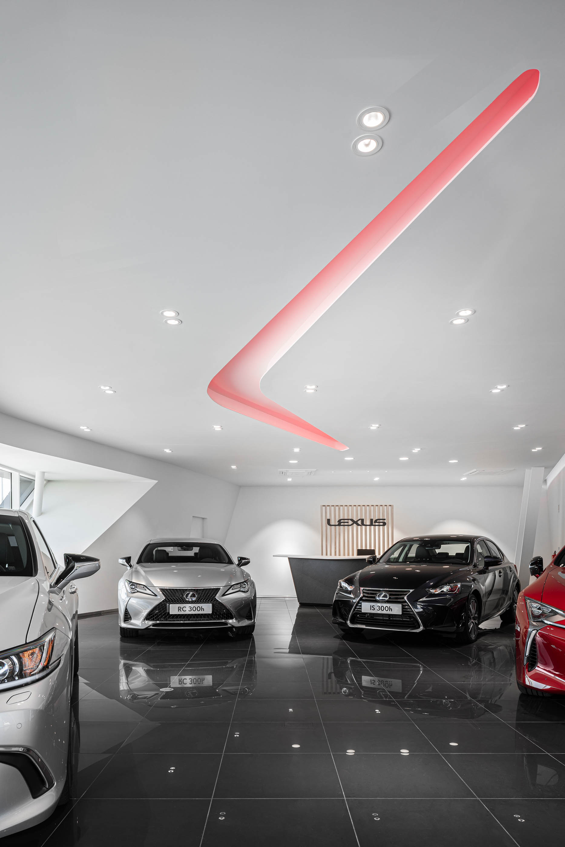Interior do stand Lexus, com carros expostos, iluminação moderna e piso brilhante, criando um ambiente elegante. — Stand Lexus Faro arquitetura Rarcon Arquitectura em Portugal