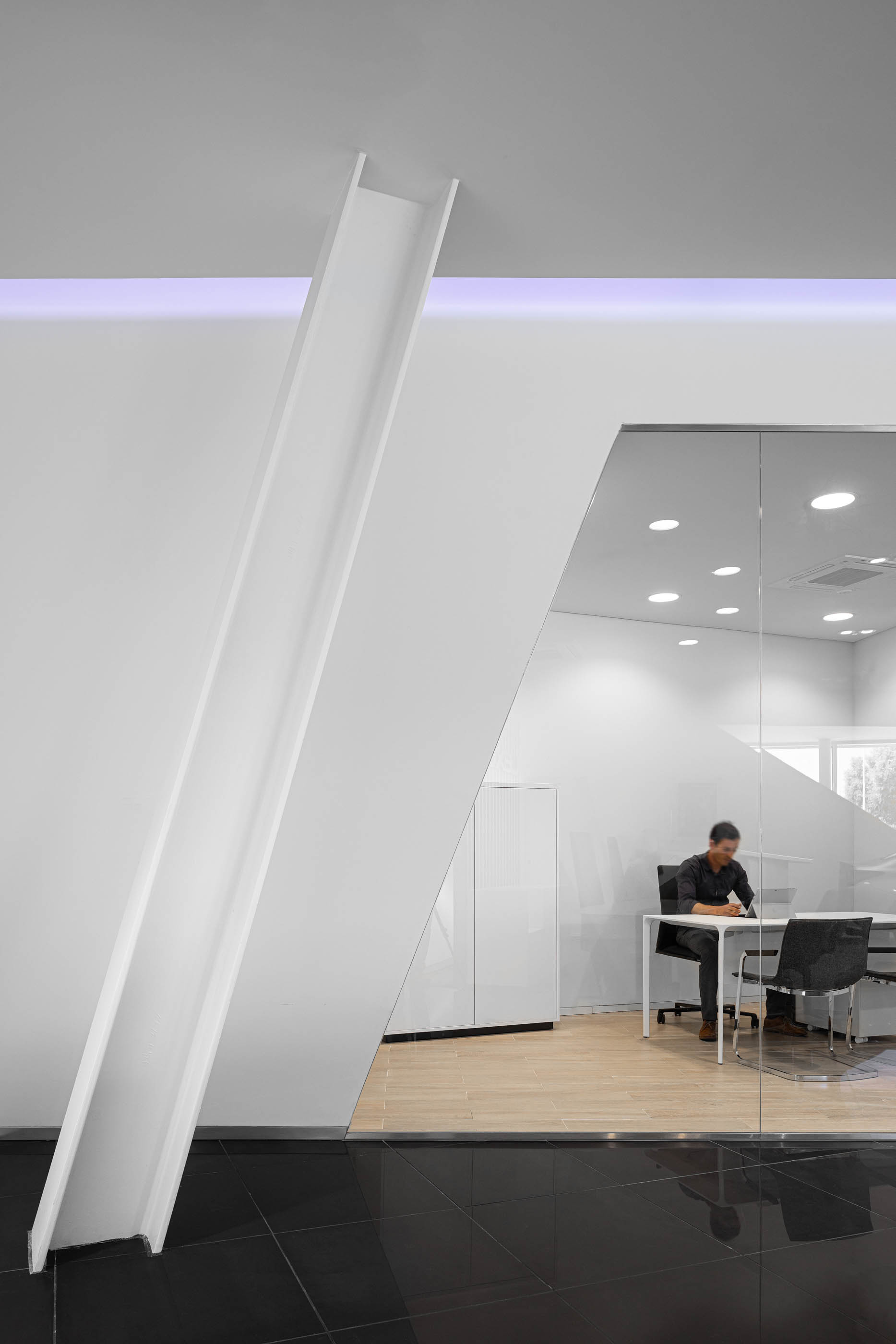 Espaço de escritório no stand Lexus, com divisórias de vidro, iluminação moderna e mobiliário minimalista. — Stand Lexus Faro arquitetura Rarcon Arquitectura em Portugal