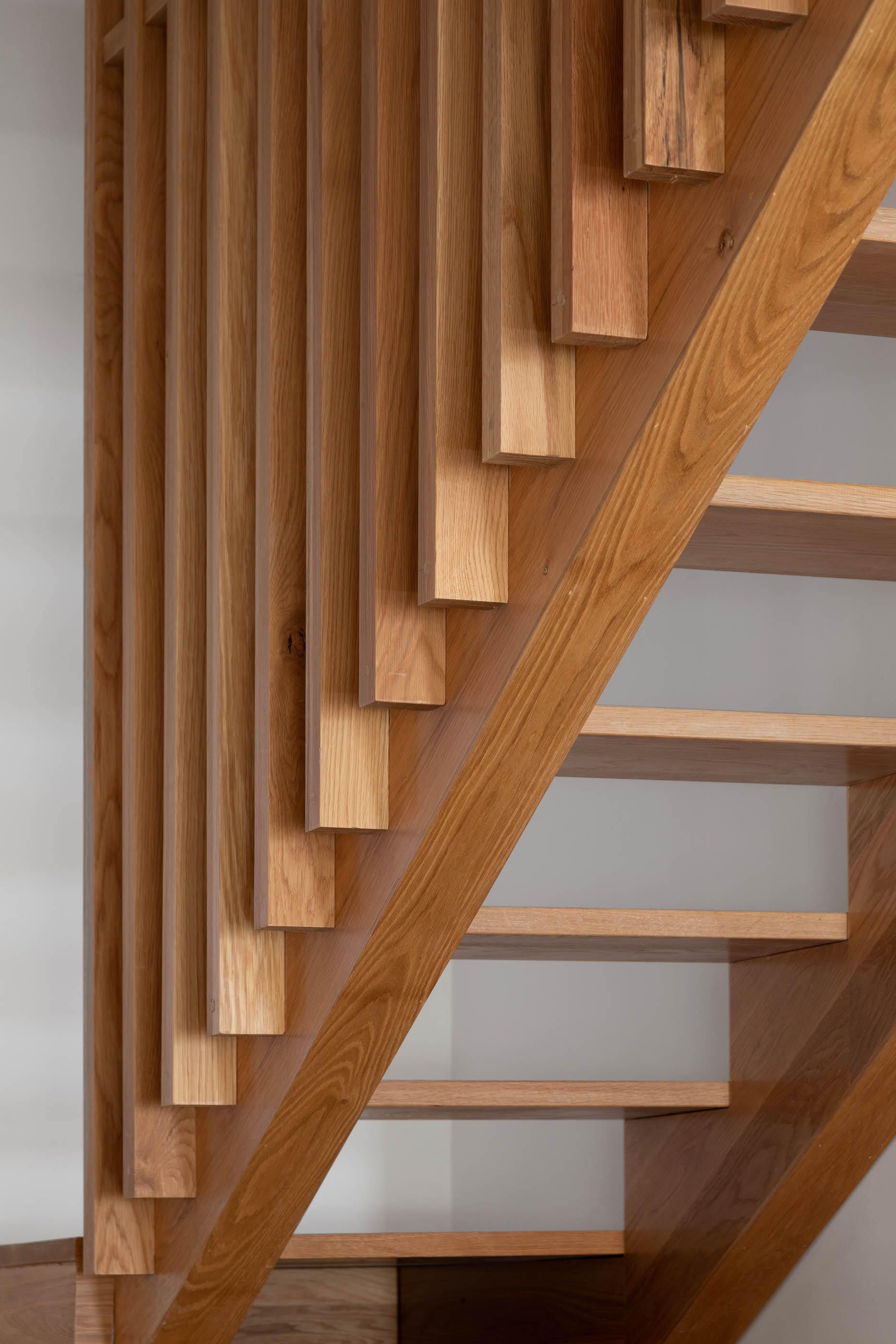 Detalhe da guarda da escada em ripas de madeira clara. — Casa GD arquitetura Esquissos Arquitectura em Portugal