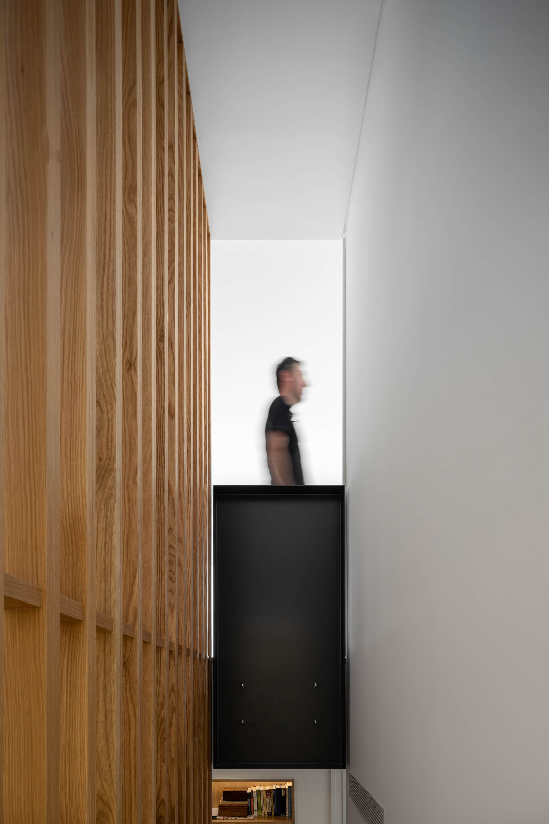 Detalhe da guarda da escada em ripas de madeira e armário preto. — Casa GD arquitetura Esquissos Arquitectura em Portugal