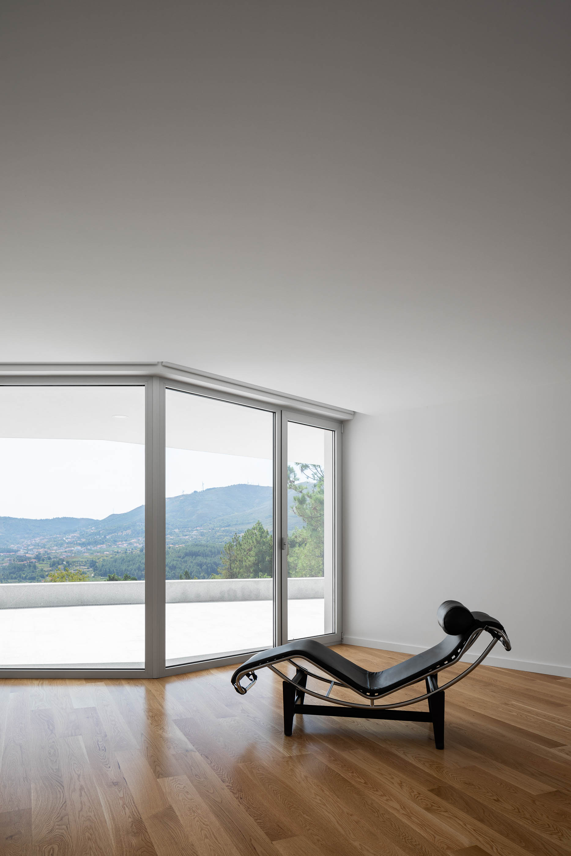 Detalhe da chaise longue no interior da sala com vista para a paisagem. — Casa em Lamego arquitetura António Ildefonso Arquitectura em Portugal