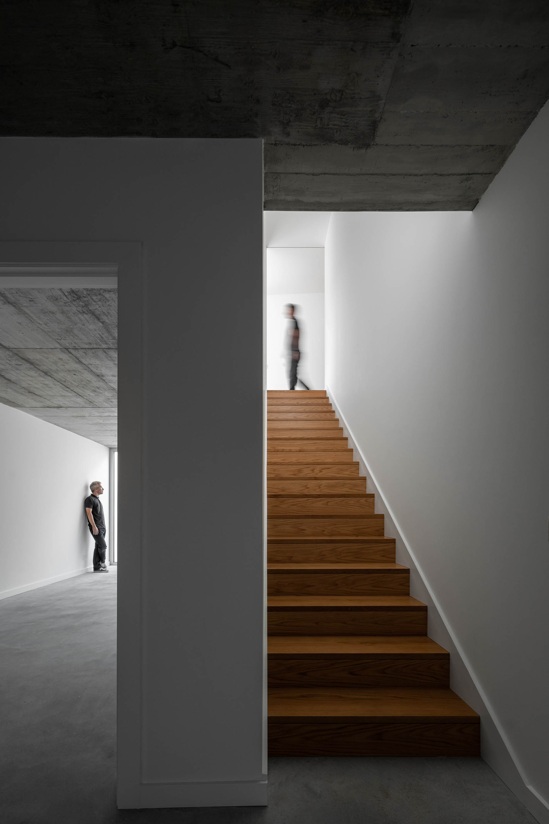 Escadas de madeira com paredes brancas e teto de betão aparente. — Casa em Lamego arquitetura António Ildefonso Arquitectura em Portugal
