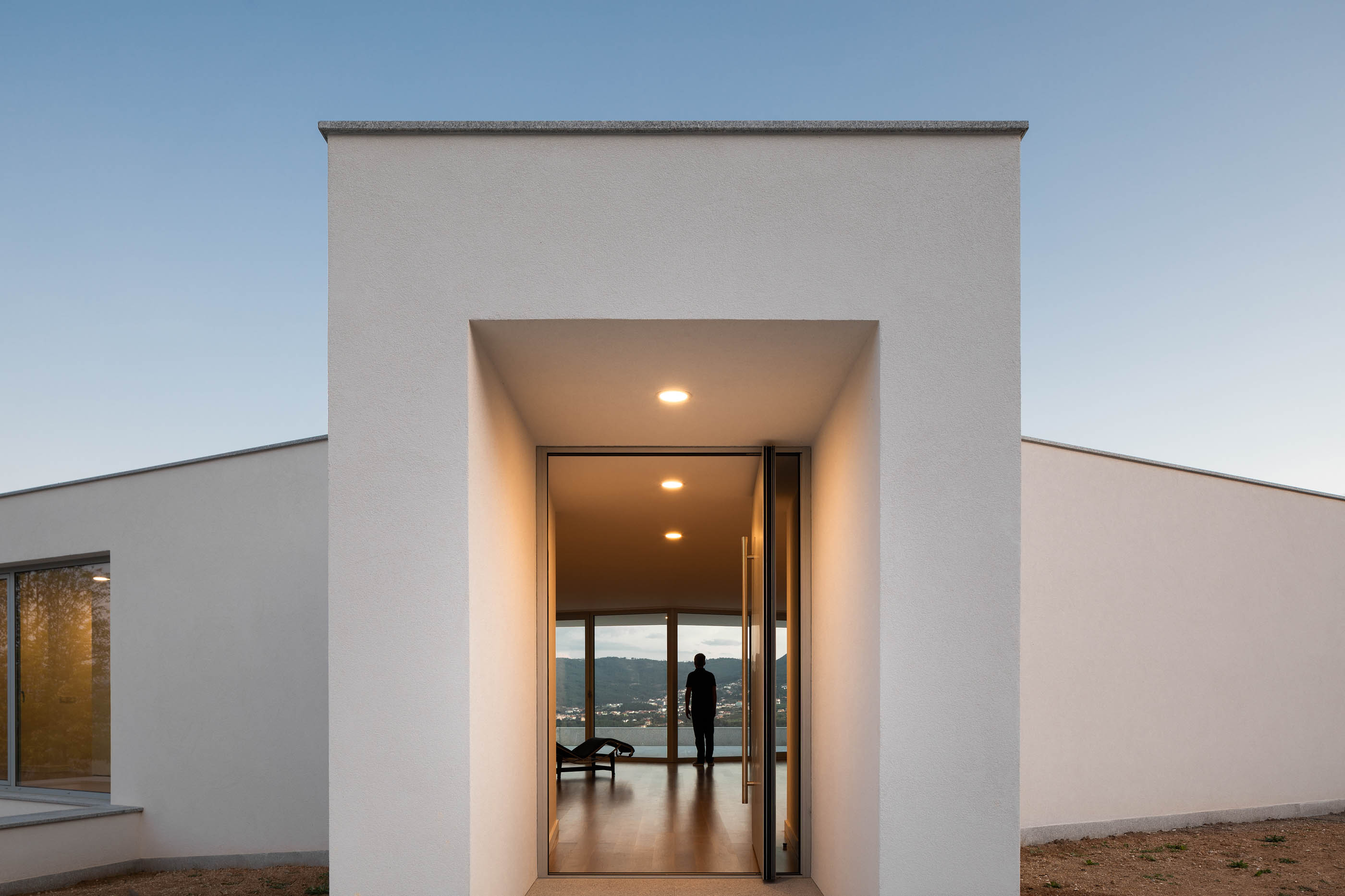 Entrada da casa com porta envidraçada e vista para o interior. — Casa em Lamego arquitetura António Ildefonso Arquitectura em Portugal