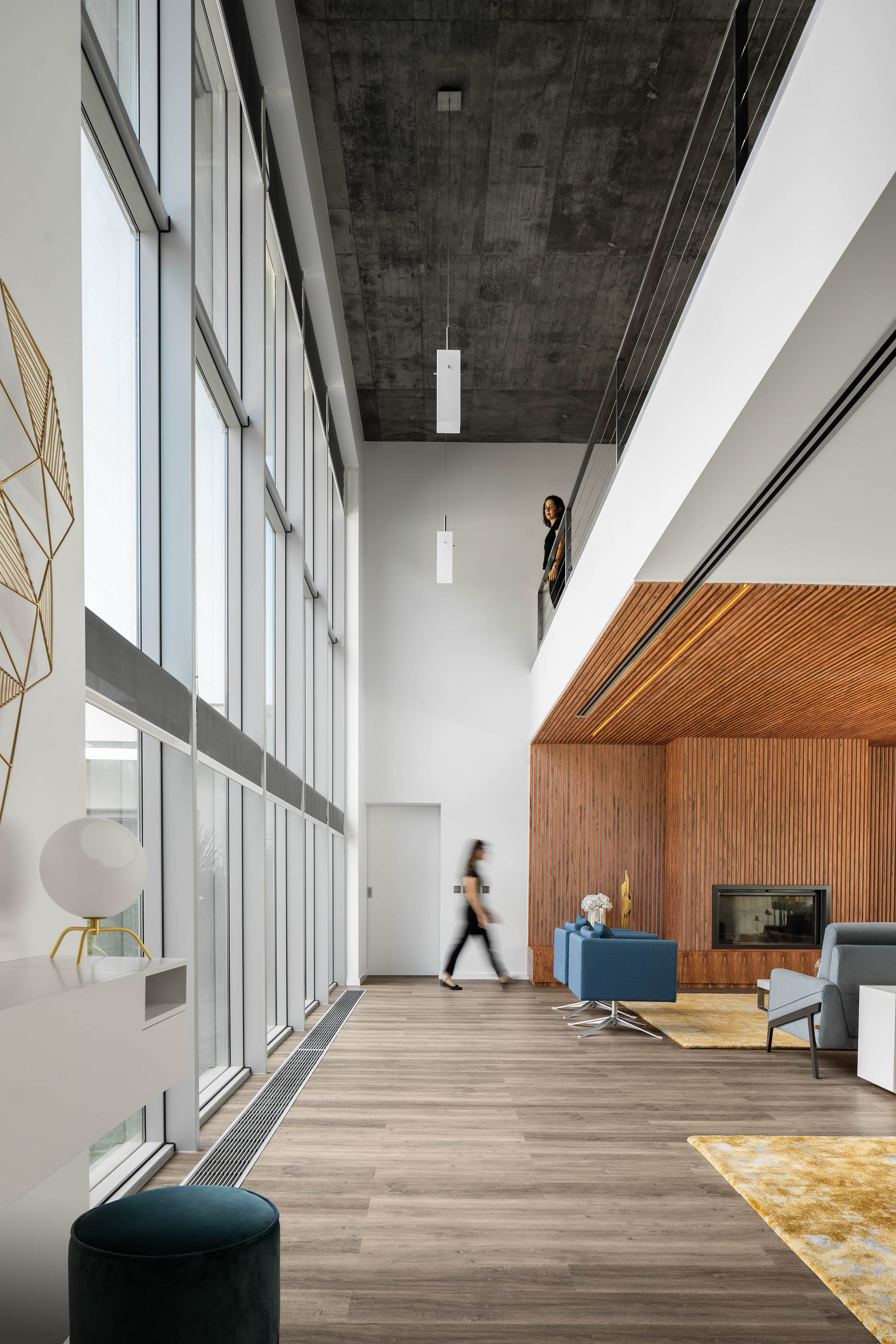 Hall de entrada com pé direito alto, janelas amplas, teto em madeira ripada e detalhes decorativos dourados. — Reabilitação Casa J arquitetura Frari em Portugal