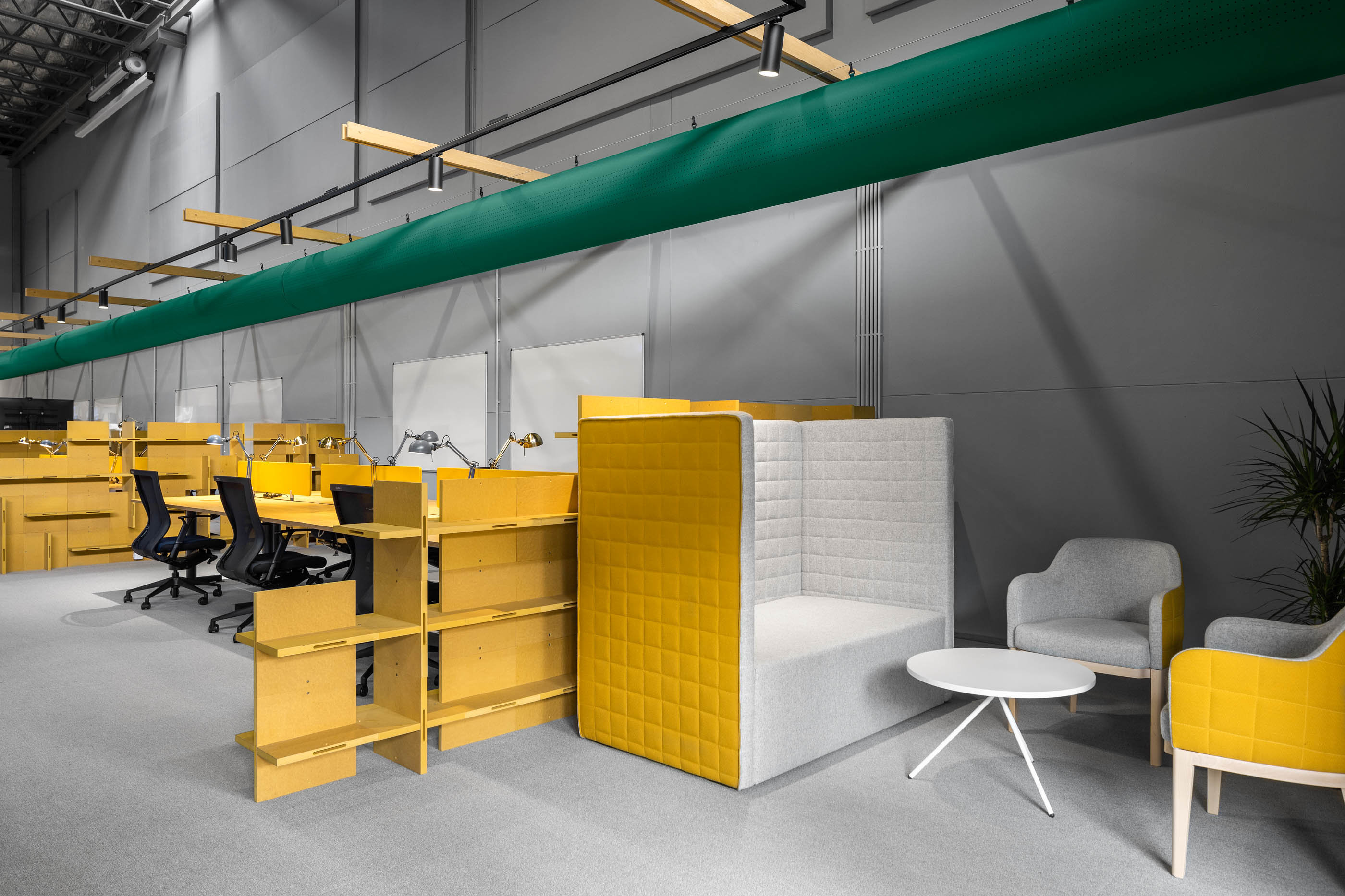Espaço amplo: Secretárias amarelas, cabine acolchoada, cadeiras cinzentas e iluminação industrial. — HBK Spectris Innovation Centre arquitetura Studium Creative Studio em Porto