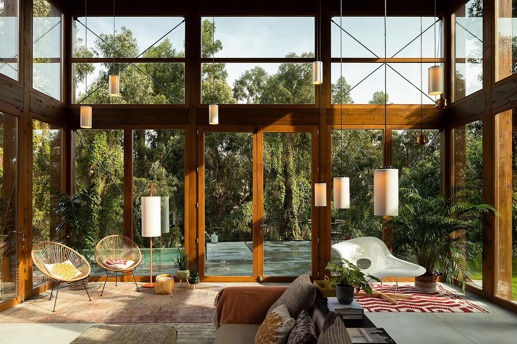 Sala de estar envidraçada com estrutura de madeira. Mobiliário de design e vista para a natureza. — Gólgota arquitetura Floret Arquitectura em Porto