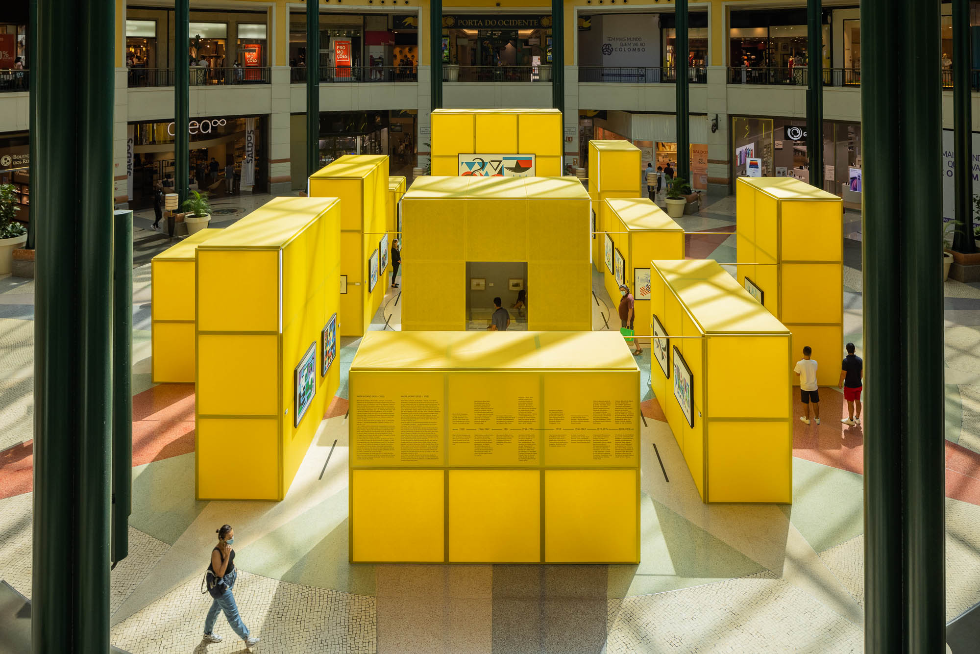 Vista aérea da instalação com cubos amarelos, mostrando a disposição no espaço do centro comercial. — Museu Temporário Nadir Afonso arquitetura Diogo Aguiar Studio em Lisboa