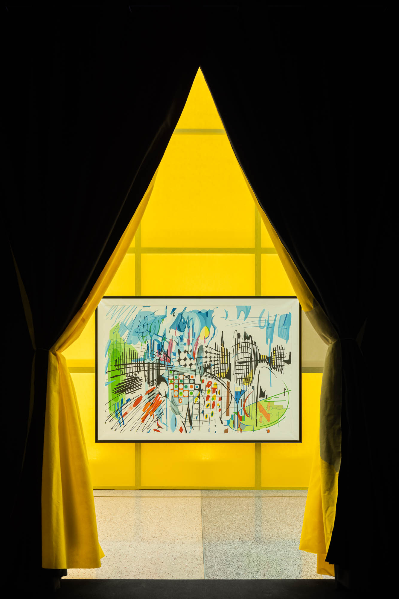 Vista de uma obra de arte através de cortinas pretas e amarelas, com painel de fundo amarelo translúcido. — Museu Temporário Nadir Afonso arquitetura Diogo Aguiar Studio em Lisboa