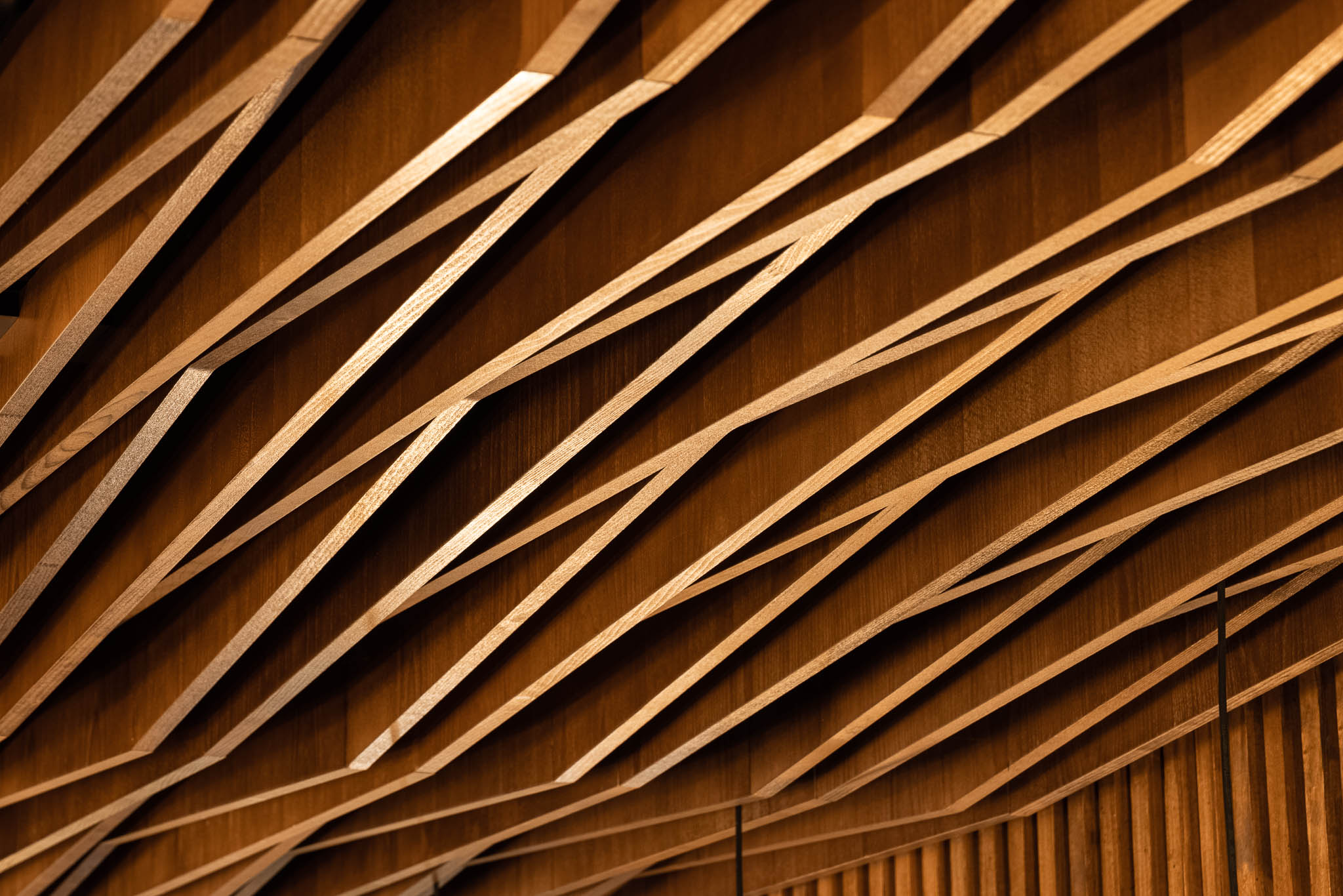 Detalhe do teto com ripas de madeira clara dispostas em padrão geométrico, criando um efeito visual interessante. — Restaurante 34 arquitetura REM'A Arquitectos em Guimarães