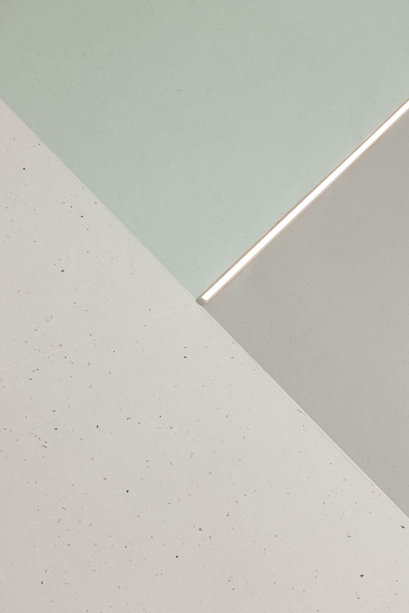 Pormenor do chão com diferentes tons de branco e verde-água, separados por uma linha de luz, criando um efeito visual interessante. — Think Health Naturopatia arquitetura BOX arquitectos em Ponta Delgada