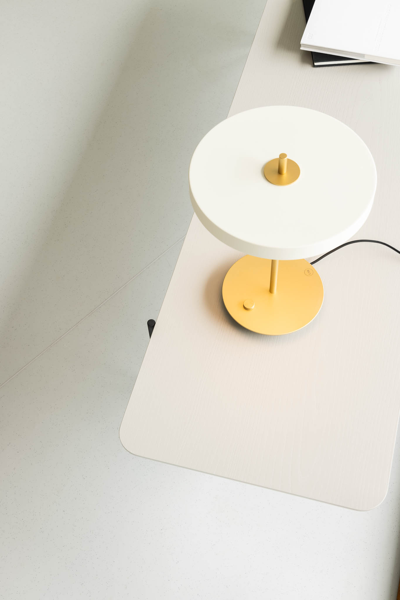 Candeeiro de mesa branco com detalhes dourados sobre uma mesa clara, destacando o design elegante e a iluminação suave. — Think Health Naturopatia arquitetura BOX arquitectos em Ponta Delgada