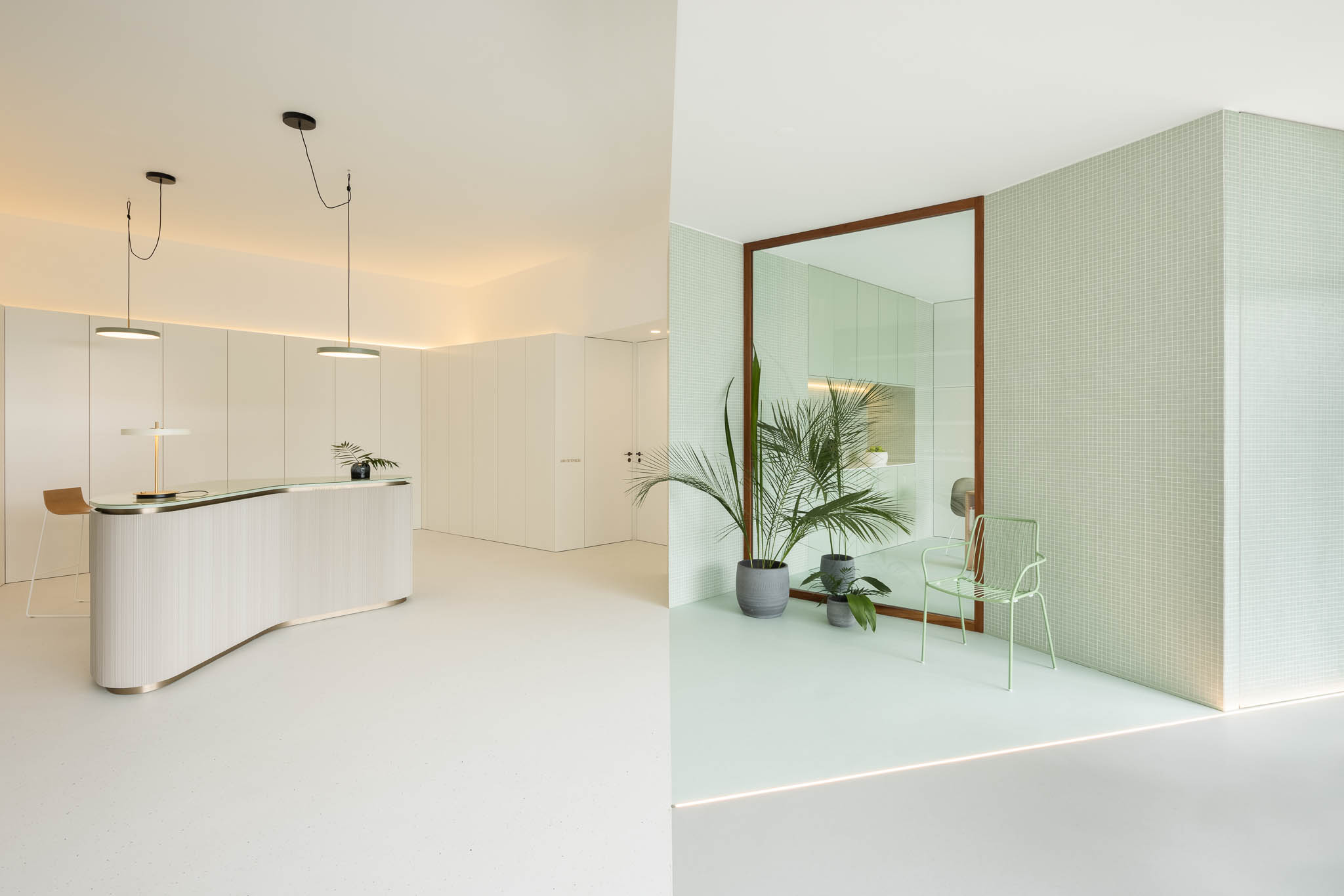 Visão geral do espaço com balcão de receção, sala de espera e azulejos verde-água, mostrando a integração dos diferentes elementos. — Think Health Naturopatia arquitetura BOX arquitectos em Ponta Delgada