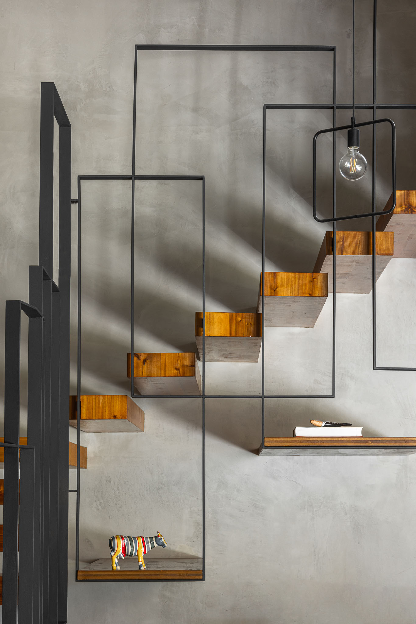 Detalhe das escadas em madeira e metal com iluminação suspensa e decoração minimalista. — Casa 15 arquitetura AM-arqstudio em Braga