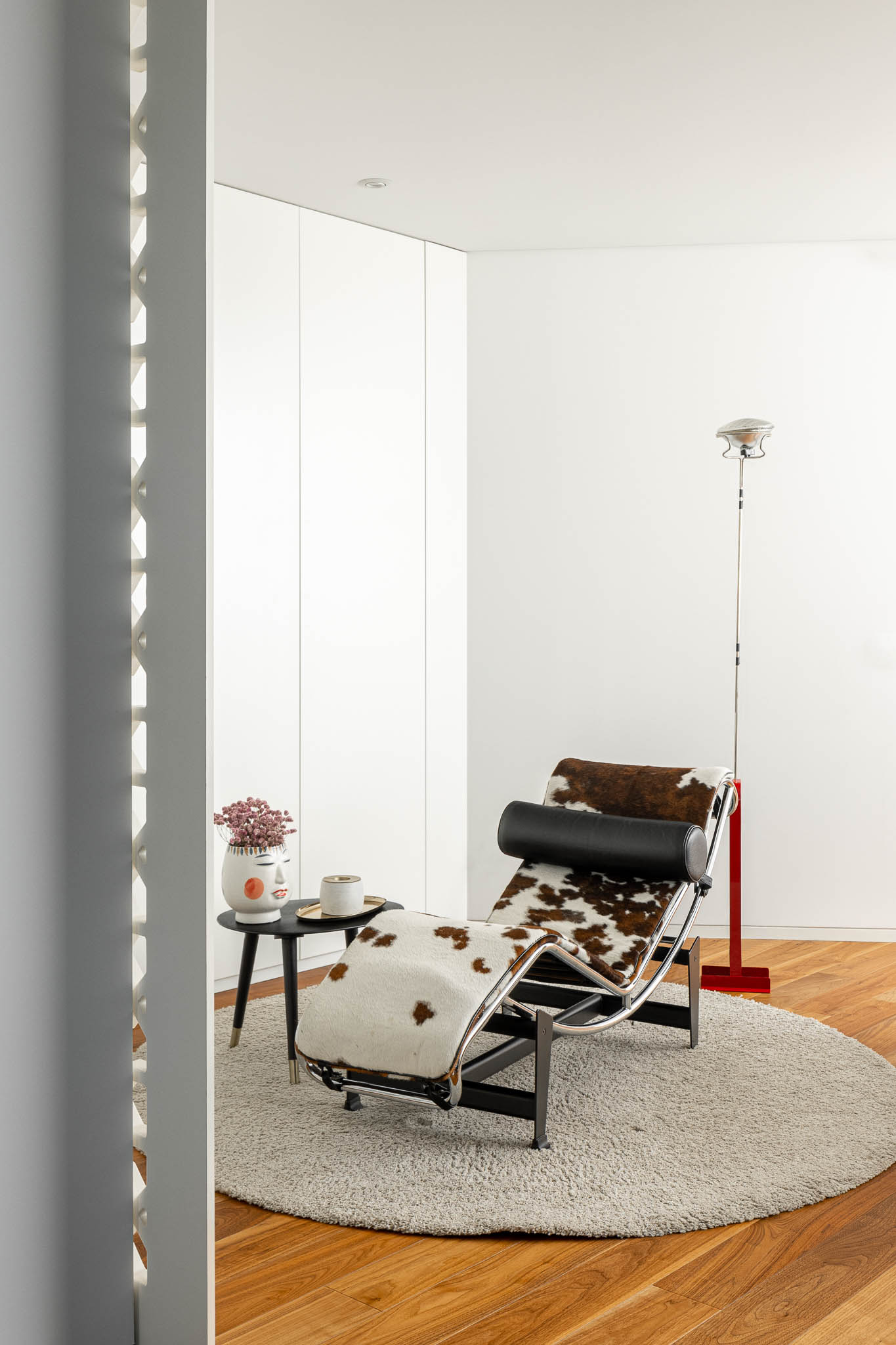 Quarto com chaise longue em pele, tapete redondo e biombo rendilhado branco ao fundo. — Casa PS arquitetura Inception Architects Studio em Braga