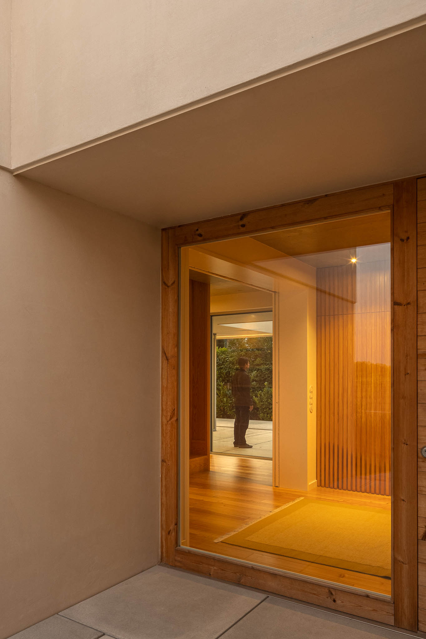 Entrada: Porta em madeira e vidro, com pavimento em madeira e alcatifa amarela. — Casa em Ílhavo arquitetura M2Senos Arquitectos em Ílhavo