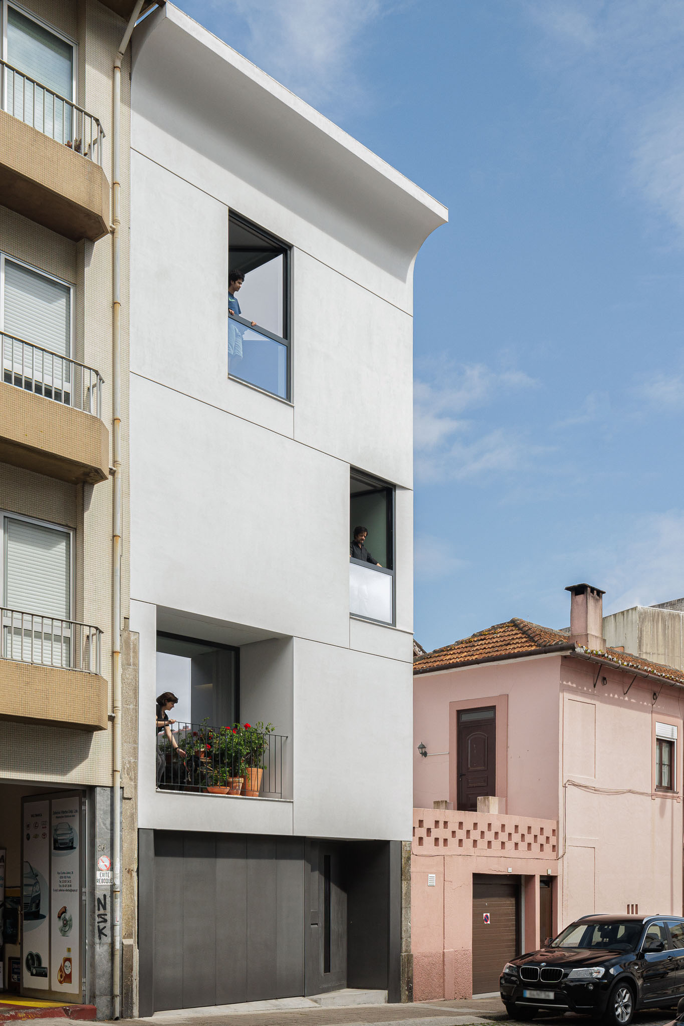 Exterior: Fachada branca da casa vertical, com janelas e varanda. — Casa Vertical arquitetura Tsou Arquitectos em Porto