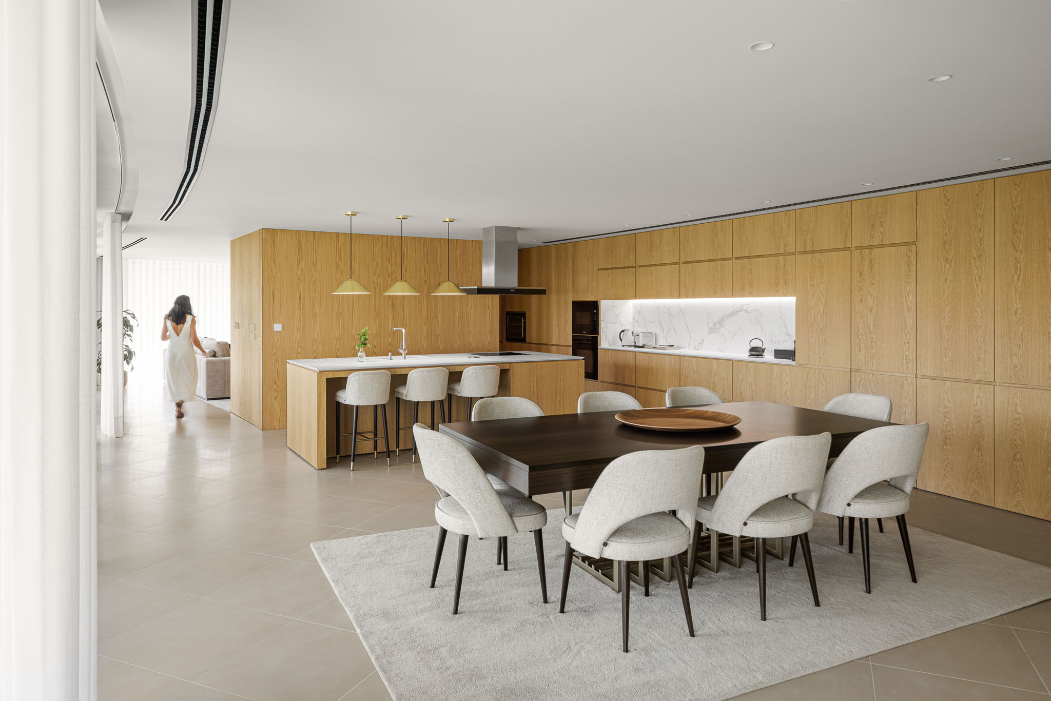 Cozinha e Sala de Jantar: Espaço amplo com armários de madeira clara, ilha central, mesa de jantar e alcatifa clara. — Casa 109 arquitetura Frari em Vagos