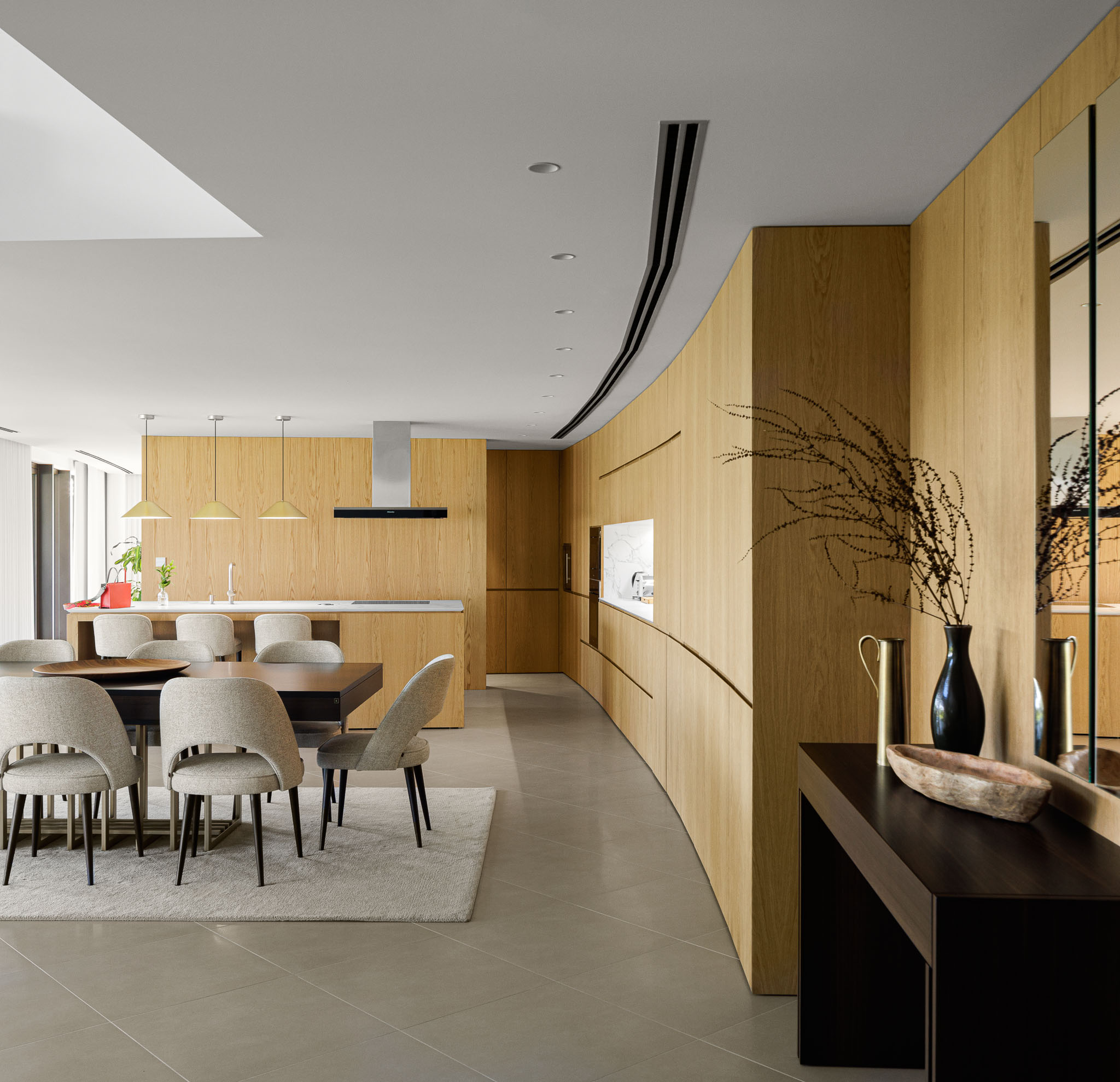 Cozinha e Sala de Jantar: Perspectiva da cozinha com ilha, zona de refeições e armários embutidos de madeira clara. — Casa 109 arquitetura Frari em Vagos