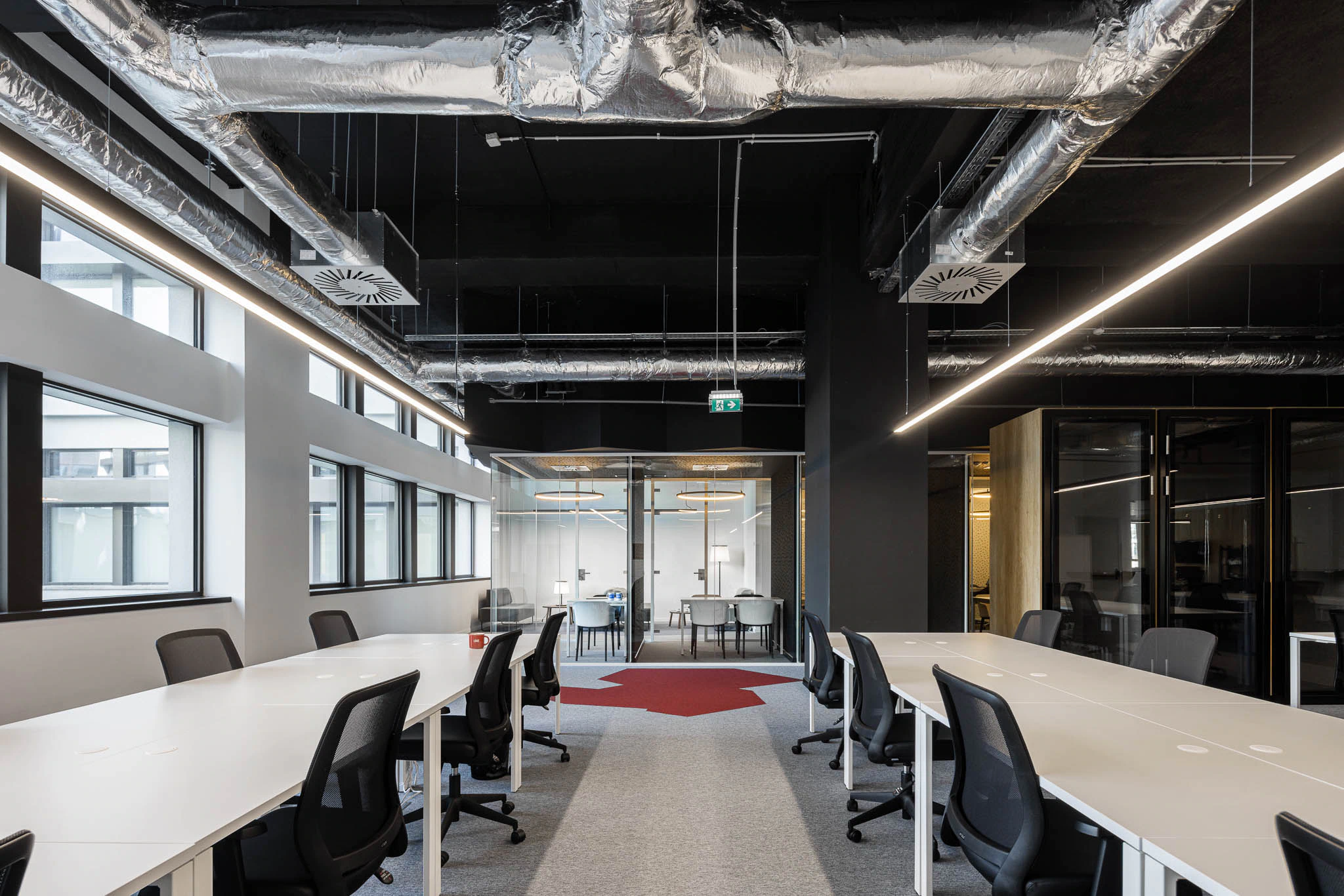 Espaço de trabalho amplo com secretárias brancas, cadeiras pretas e salas de reunião envidraçadas. — Bold by Devoteam: Escritório Porto arquitetura Inception Architects Studio em Porto