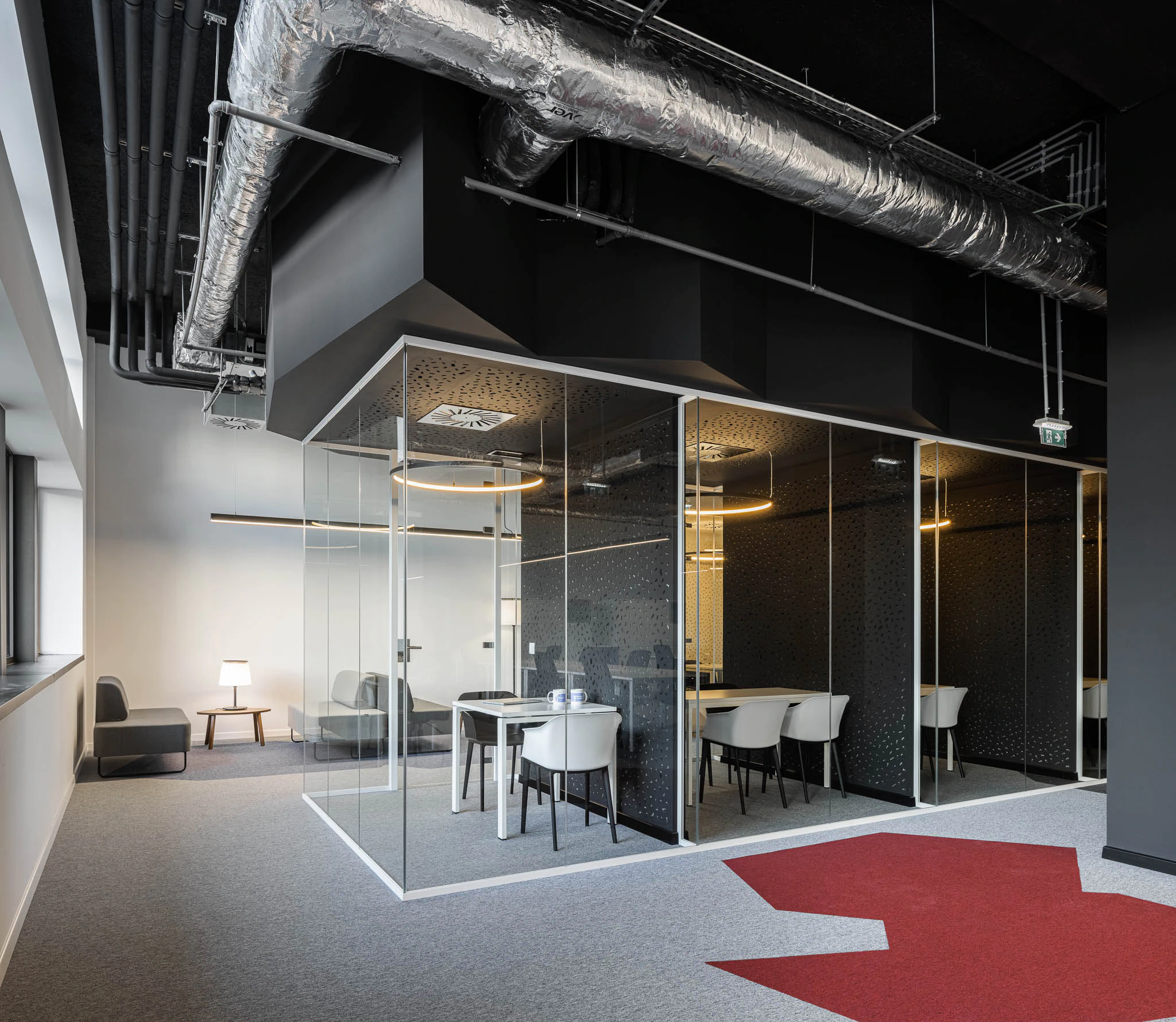 Salas de reunião envidraçadas com iluminação circular e padrão no vidro, sobre um tapete com seta vermelha. — Bold by Devoteam: Escritório Porto arquitetura Inception Architects Studio em Porto