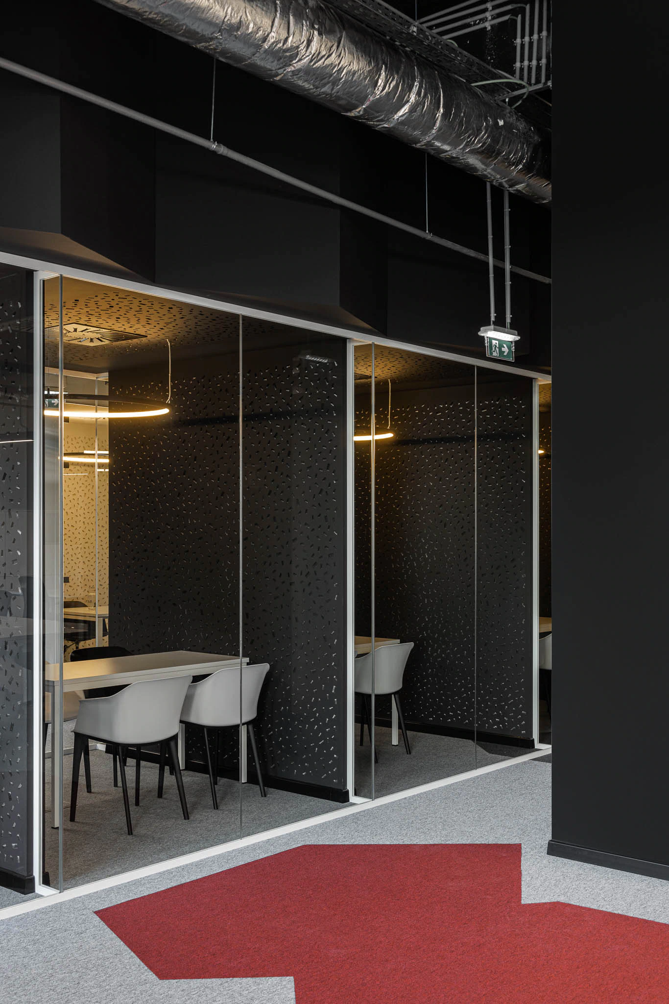 Salas de reunião envidraçadas com padrão no vidro e tapete com seta vermelha no chão. — Bold by Devoteam: Escritório Porto arquitetura Inception Architects Studio em Porto
