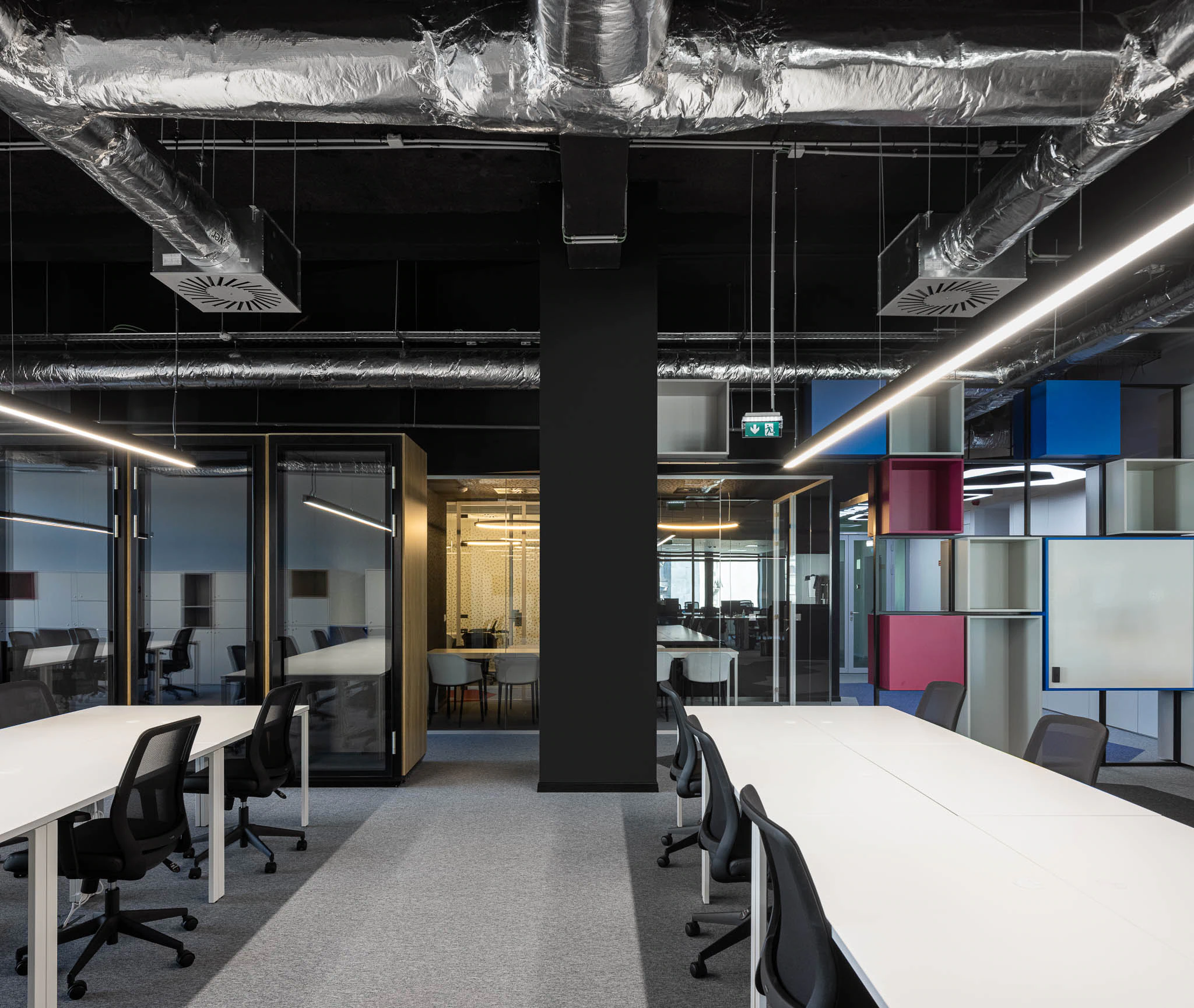 Espaço de trabalho com cabines telefónicas, salas de reunião envidraçadas e estantes coloridas suspensas. — Bold by Devoteam: Escritório Porto arquitetura Inception Architects Studio em Porto