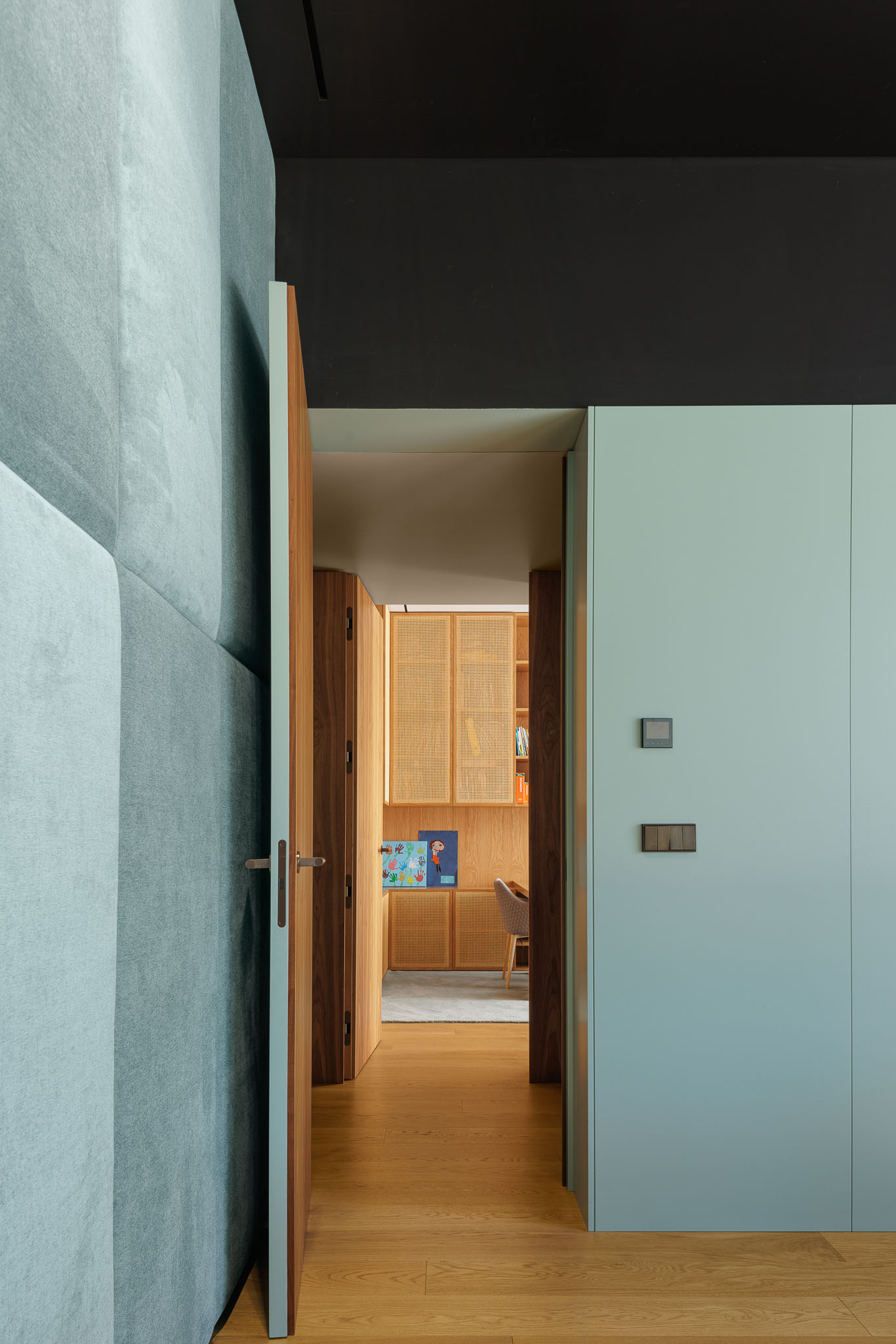 Corredor: Corredor com pavimento em madeira, paredes em tons claros e porta aberta para escritório. — Casa D arquitetura L2C Arquitetura em Braga