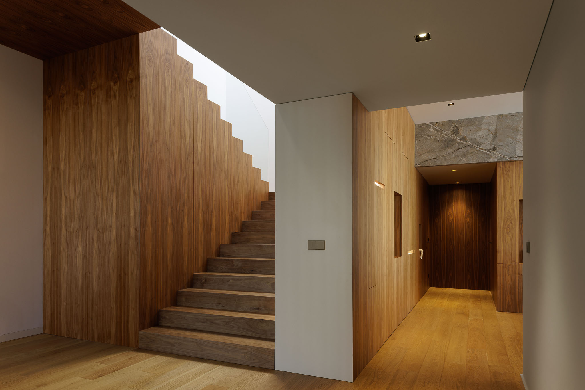 Escadas: Escadas em madeira com iluminação embutida e parede revestida a madeira. — Casa D arquitetura L2C Arquitetura em Braga