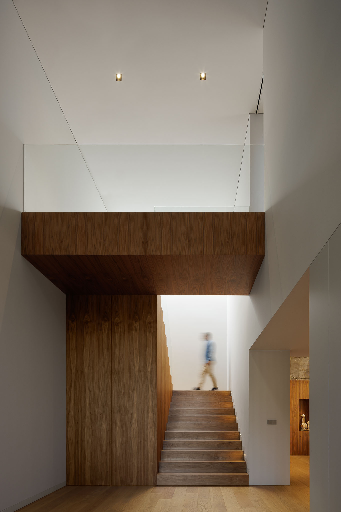 Hall: Hall de entrada com escadas em madeira, guarda-corpo em vidro e pavimento em madeira. — Casa D arquitetura L2C Arquitetura em Braga