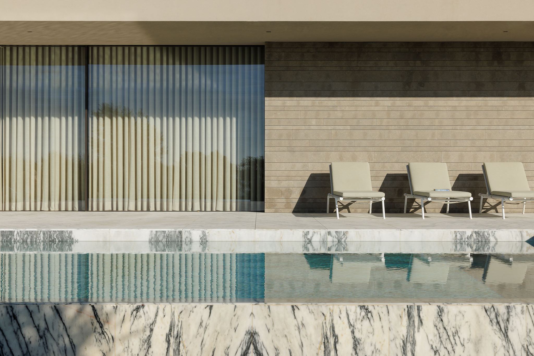 Exterior: Vista da casa com piscina, alpendre com plantas e zona de estar com sofás. — Casa D arquitetura L2C Arquitetura em Braga