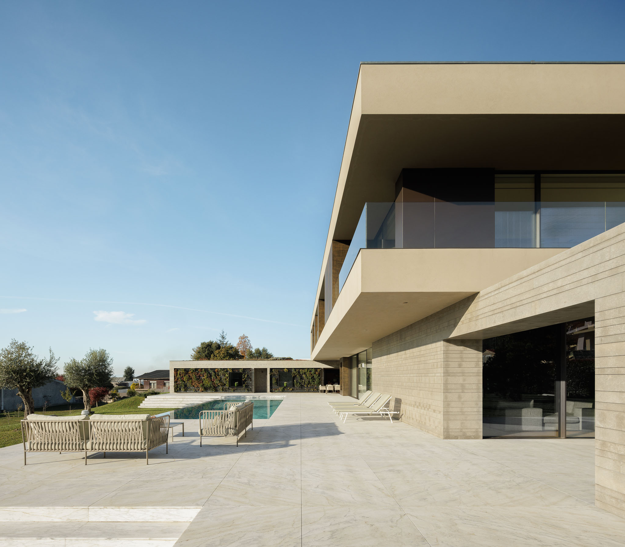 Corredor: Corredor com pavimento em madeira, armários embutidos e janela com vista para o jardim. — Casa D arquitetura L2C Arquitetura em Braga
