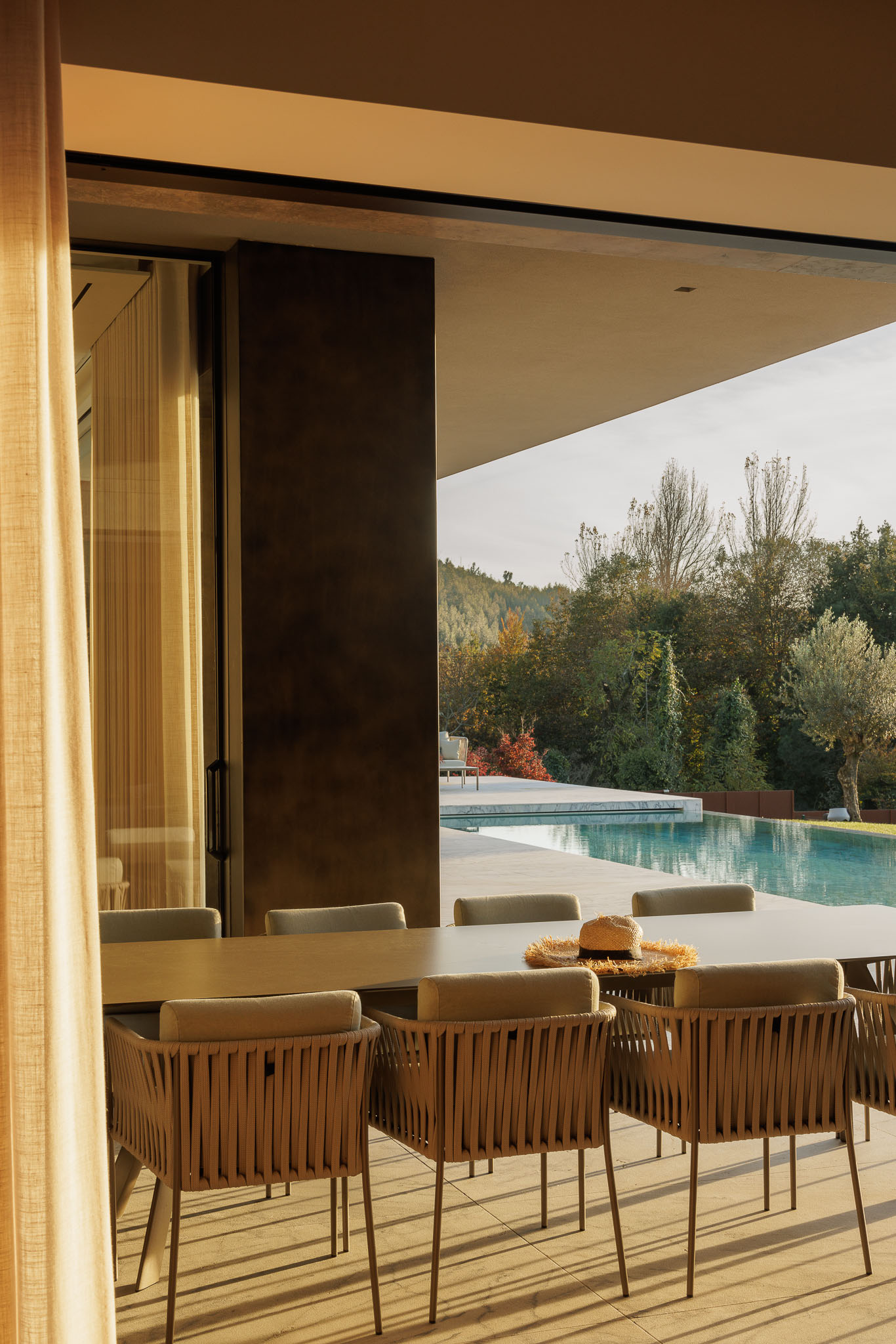 Sala de estar: Sala de estar com mesa de jantar, lareira em mármore e pavimento em madeira. — Casa D arquitetura L2C Arquitetura em Braga