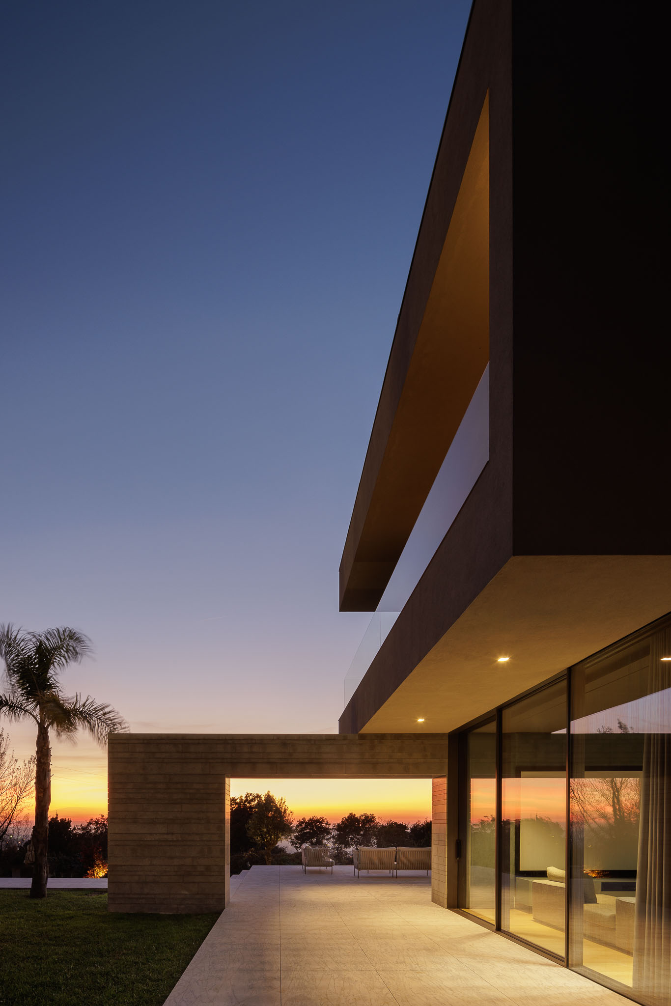 Sala de estar: Sala de estar com lareira em mármore, sofás em pele e vista para o exterior. — Casa D arquitetura L2C Arquitetura em Braga
