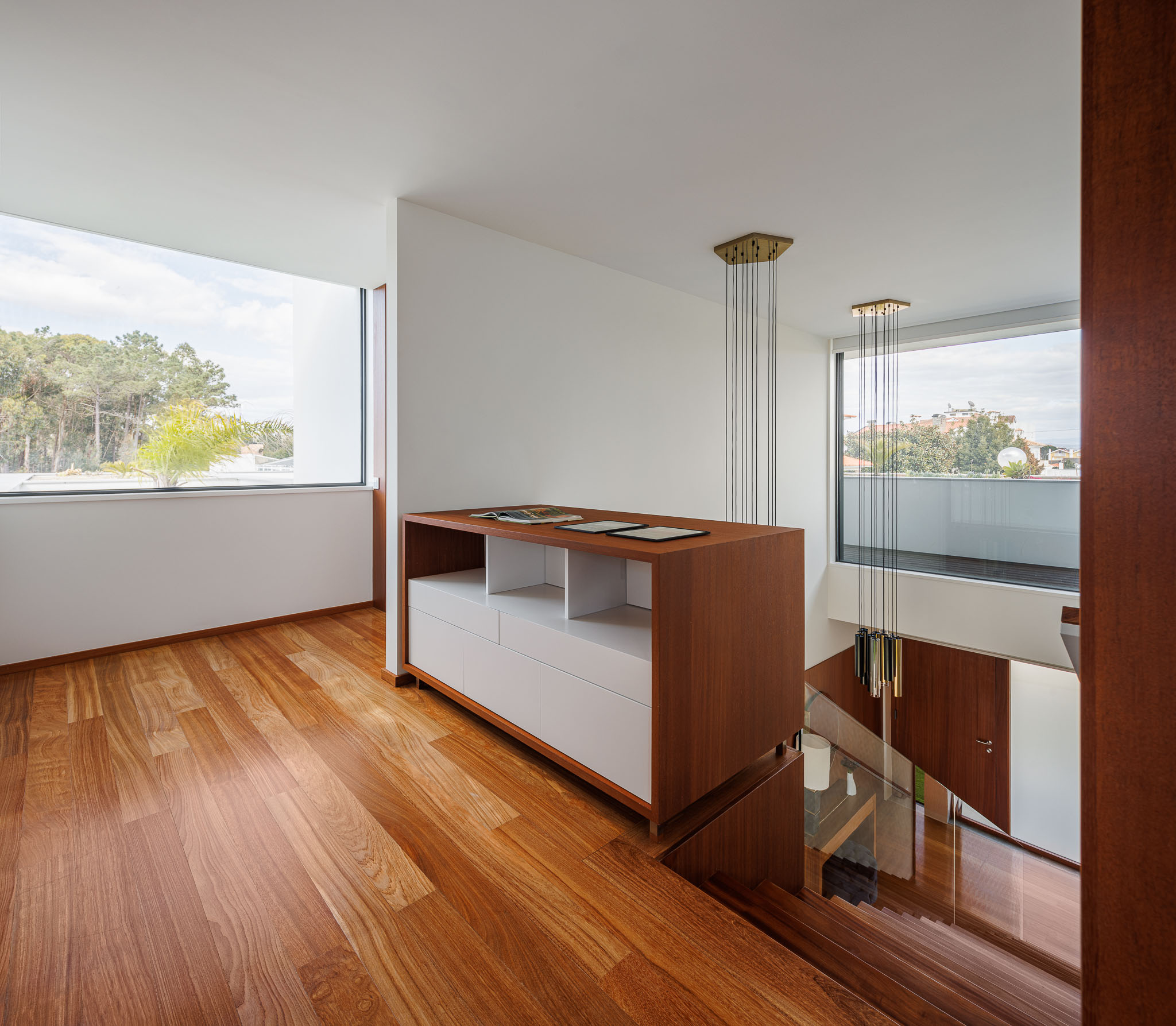 Escritório: Pavimento em madeira, móvel em madeira e branco, com vista para o exterior. — Casa R.V. arquitetura Atelier d´Arquitectura Lopes da Costa em Ovar