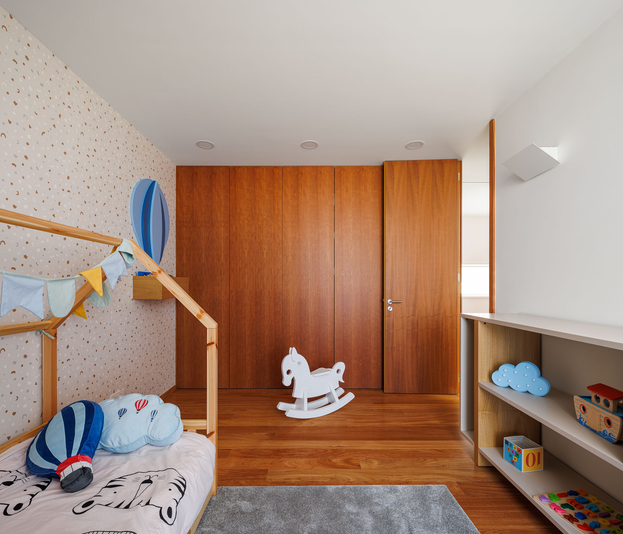 Quarto infantil: Cama em madeira, papel de parede decorativo e armários embutidos em madeira. — Casa R.V. arquitetura Atelier d´Arquitectura Lopes da Costa em Ovar