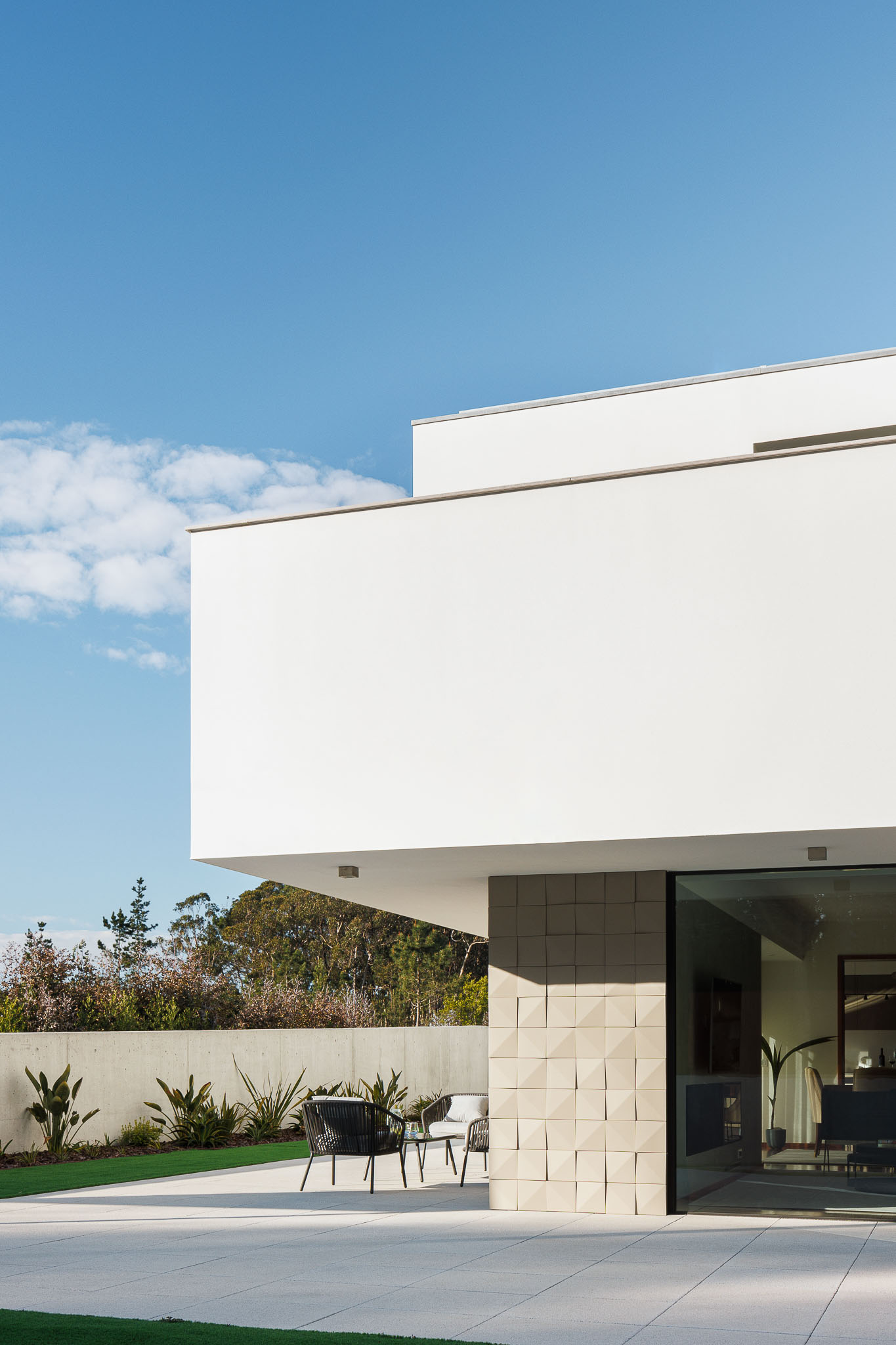 Exterior: Fachada minimalista com revestimento branco e detalhes em pedra. — Casa R.V. arquitetura Atelier d´Arquitectura Lopes da Costa em Ovar