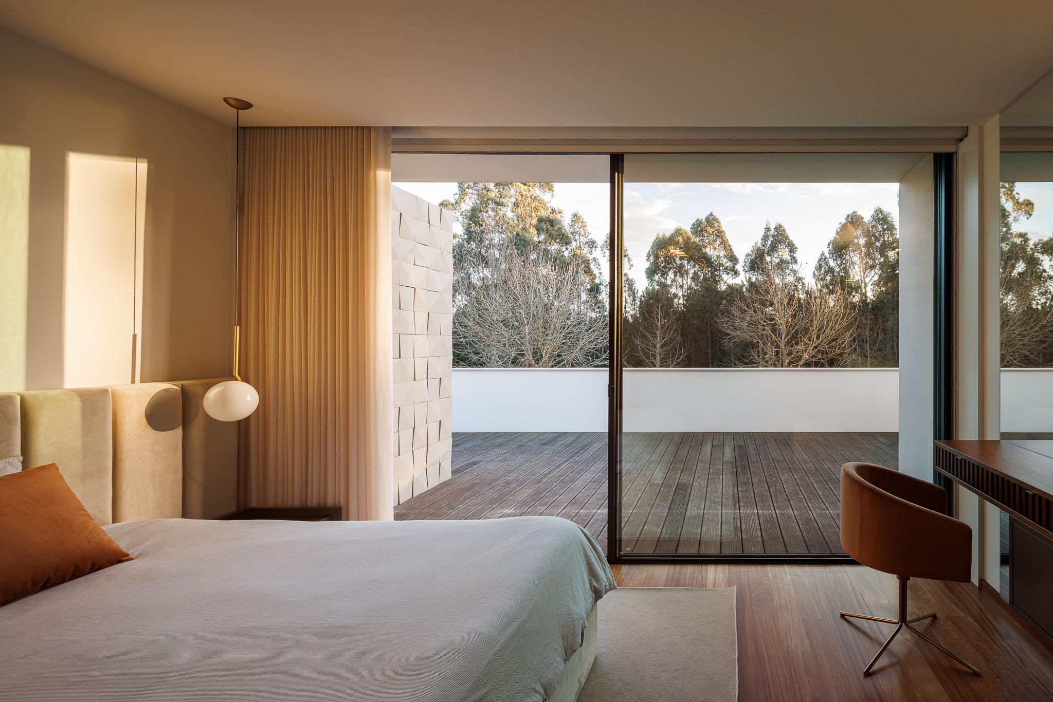 Quarto: Cama com cabeceira em tecido, alcatifa clara e vista para o terraço exterior. — Casa R.V. arquitetura Atelier d´Arquitectura Lopes da Costa em Ovar