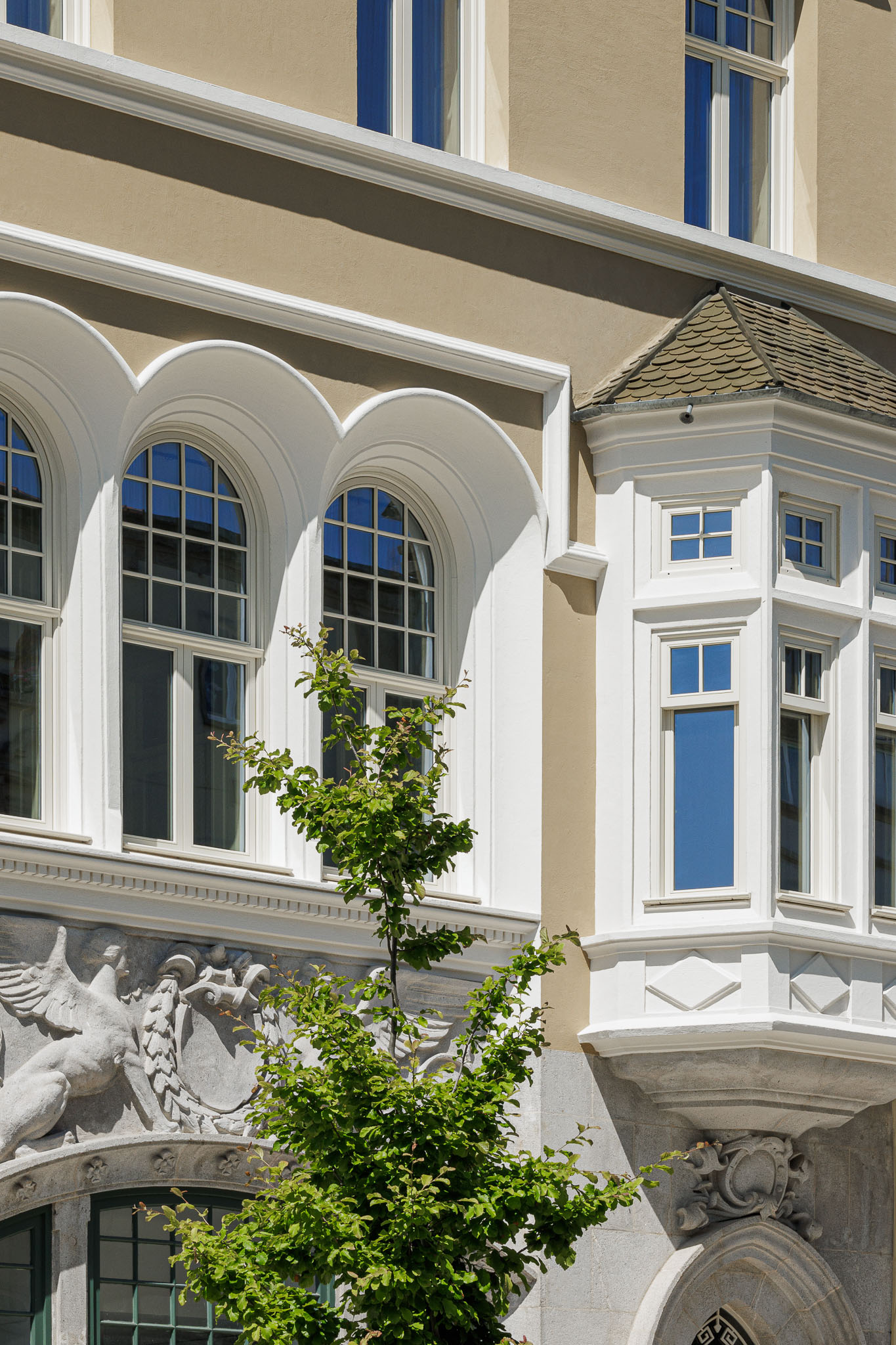 Fachada: Detalhe da fachada com janelas em arco, sacada e ornamentos em pedra, mostrando a arquitetura clássica do edifício. — Villa Theatro arquitetura arquitectos aliados em Braga