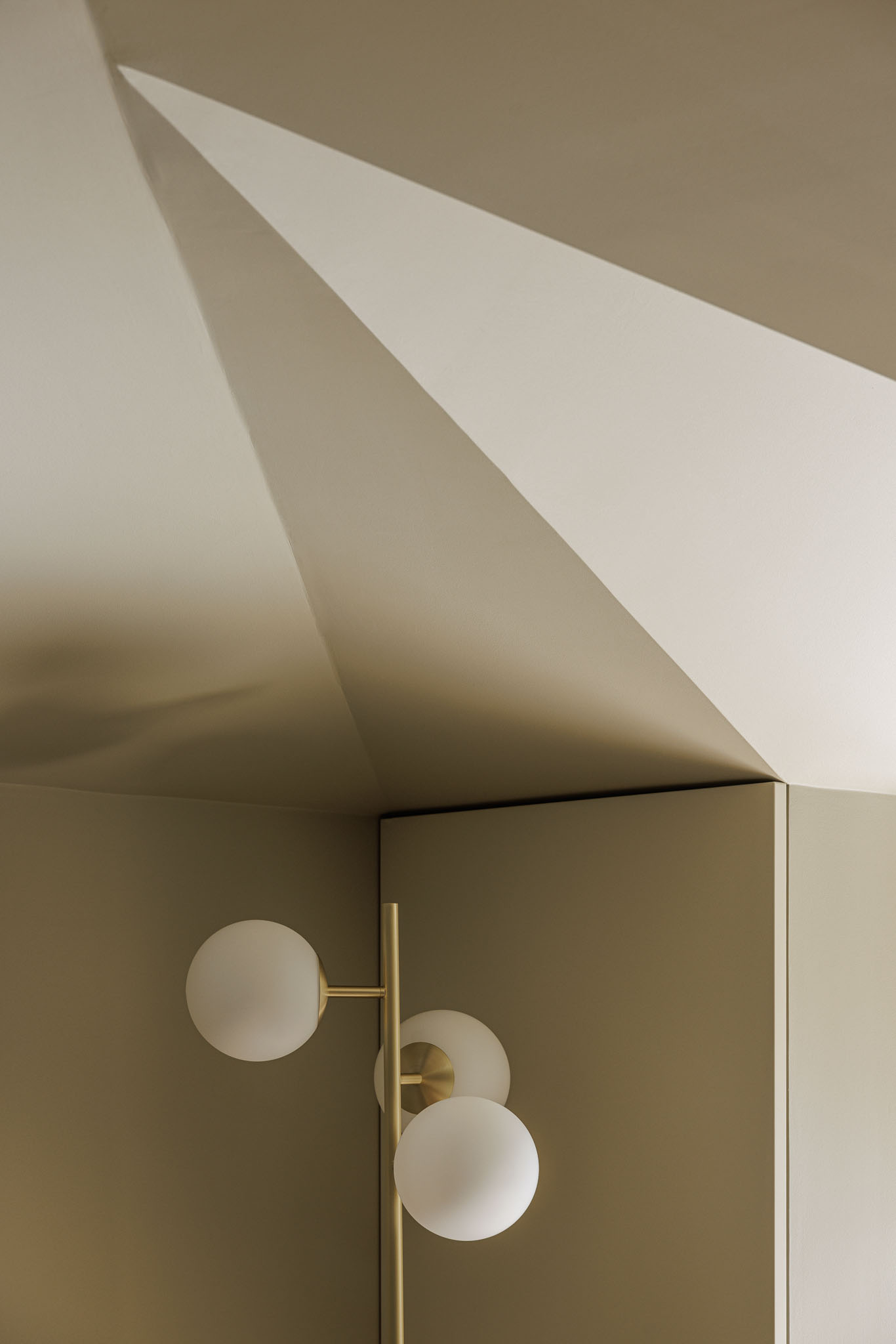 Teto: Detalhe do teto inclinado com padrão geométrico e candeeiro de pé com globos brancos. — Villa Theatro arquitetura arquitectos aliados em Braga