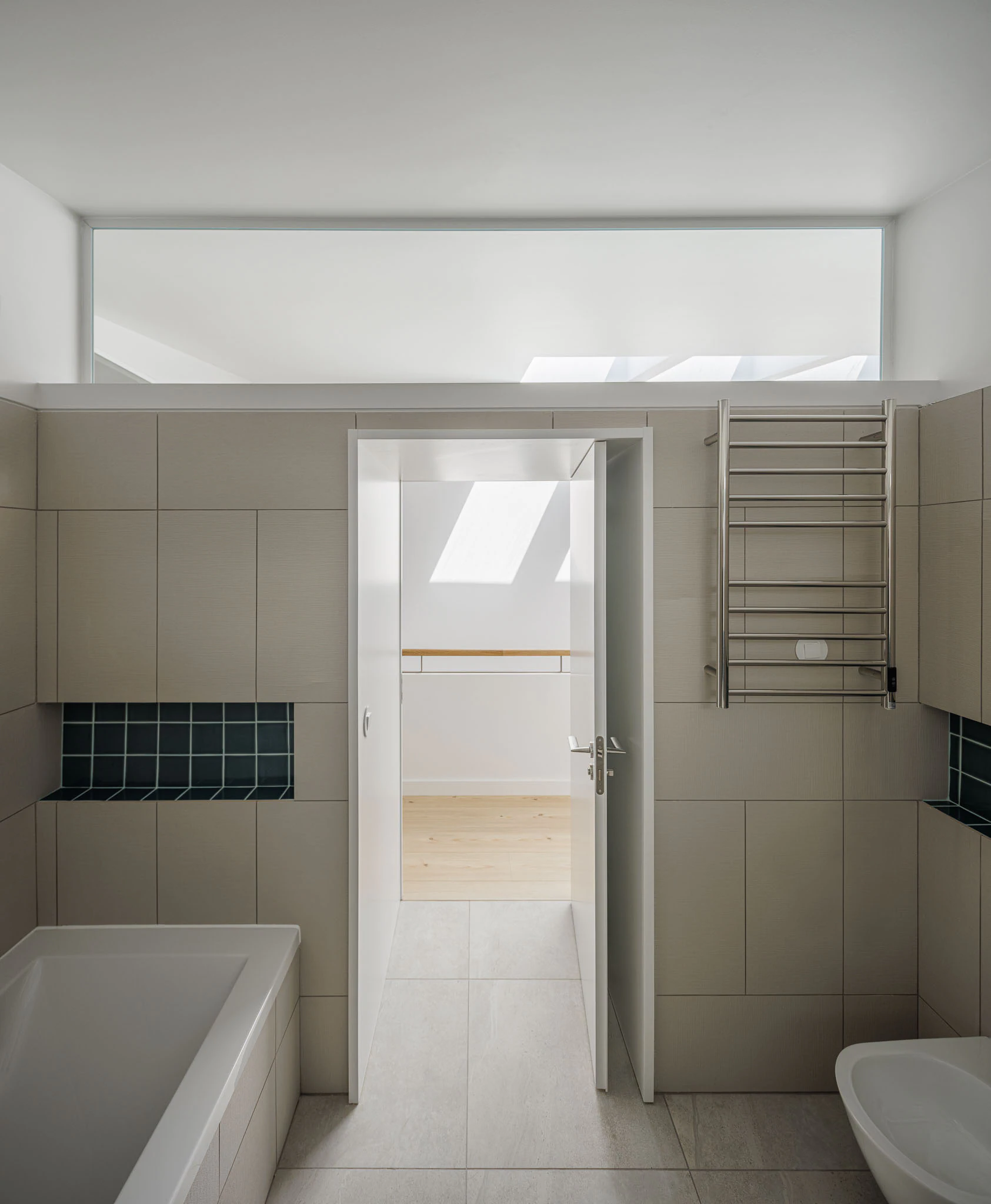 Casa de banho com banheira, lavatório e azulejos cinzentos e azuis. Design moderno e funcional. — Casas do Pinhal arquitetura Pk Arquitetos em Estoril