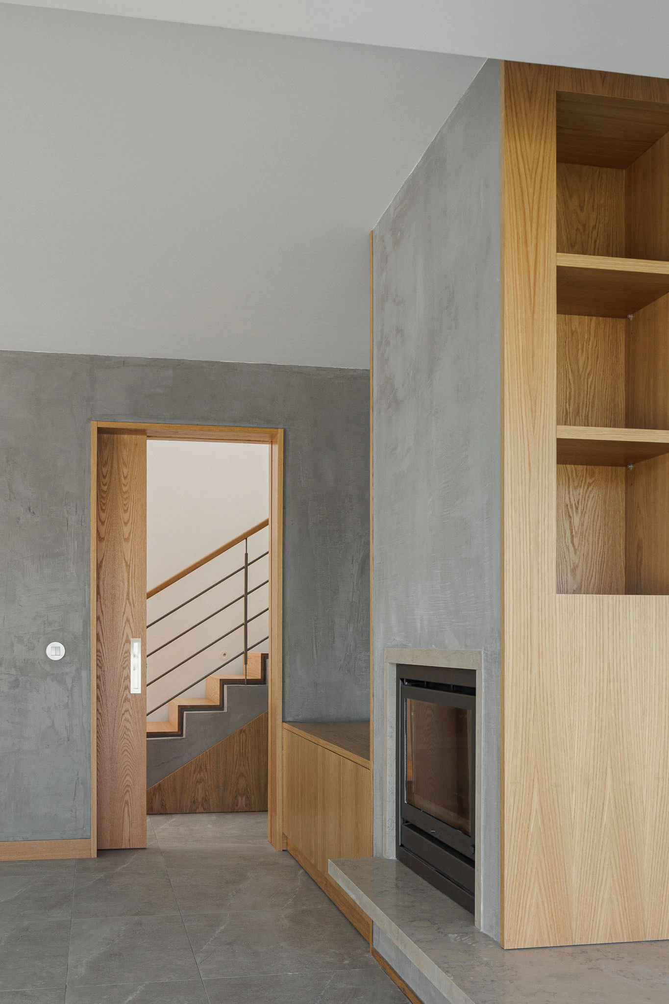 Detalhe de lareira, estantes de madeira e porta de correr. Design interior moderno e funcional. — Casas do Pinhal arquitetura Pk Arquitetos em Estoril