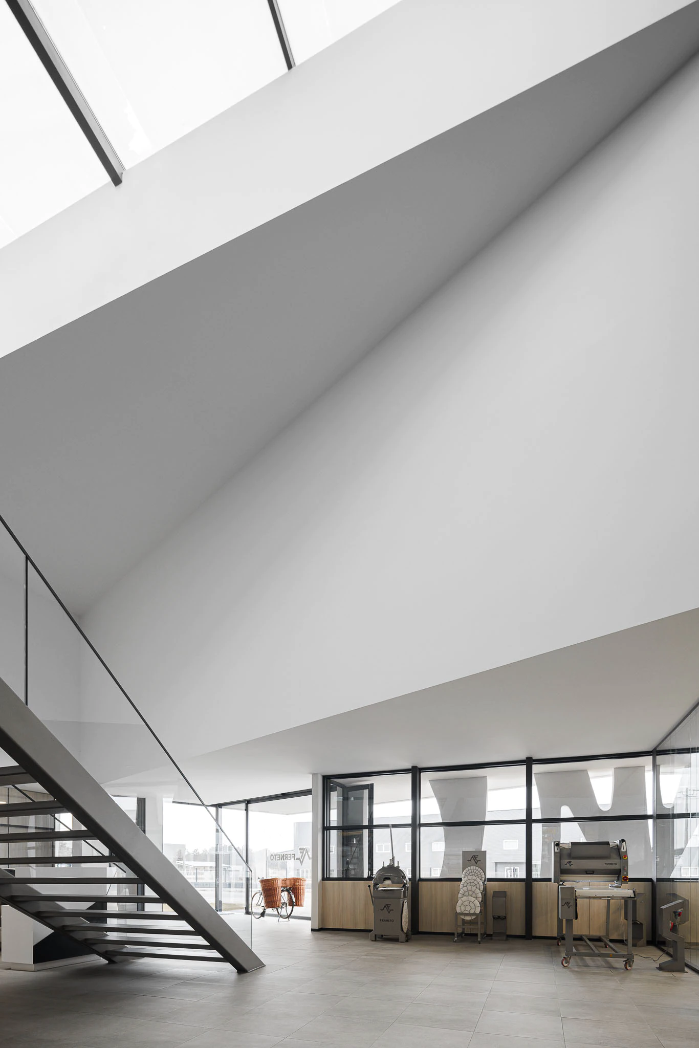 Interior: Pé direito alto, escada metálica, divisórias em vidro e mobiliário industrial exposto. — Ferneto arquitetura Rómulo Neto Arquitectos em Vagos