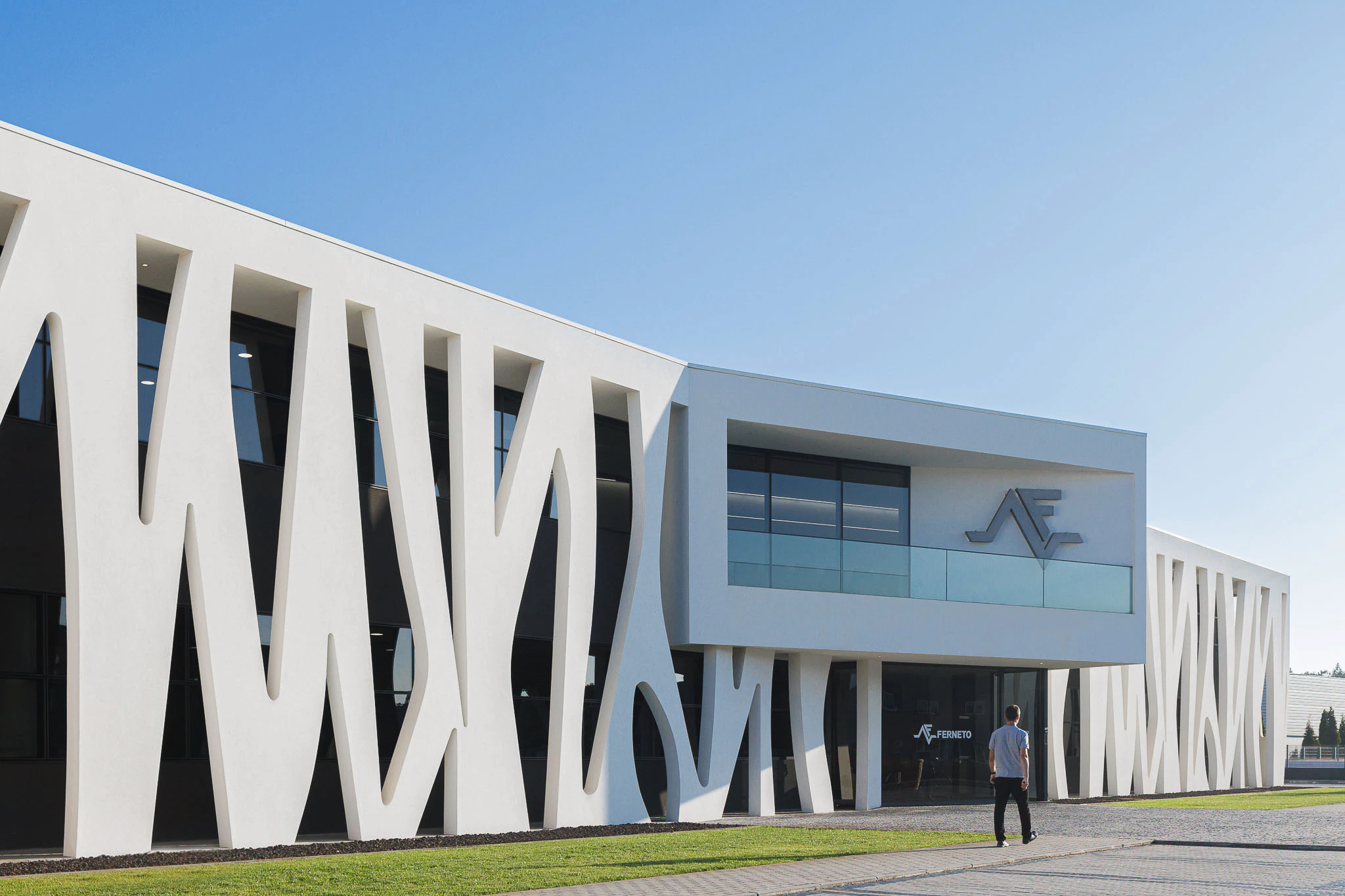 Exterior: Edifício com fachada orgânica, entrada principal e logótipo da empresa. — Ferneto arquitetura Rómulo Neto Arquitectos em Vagos