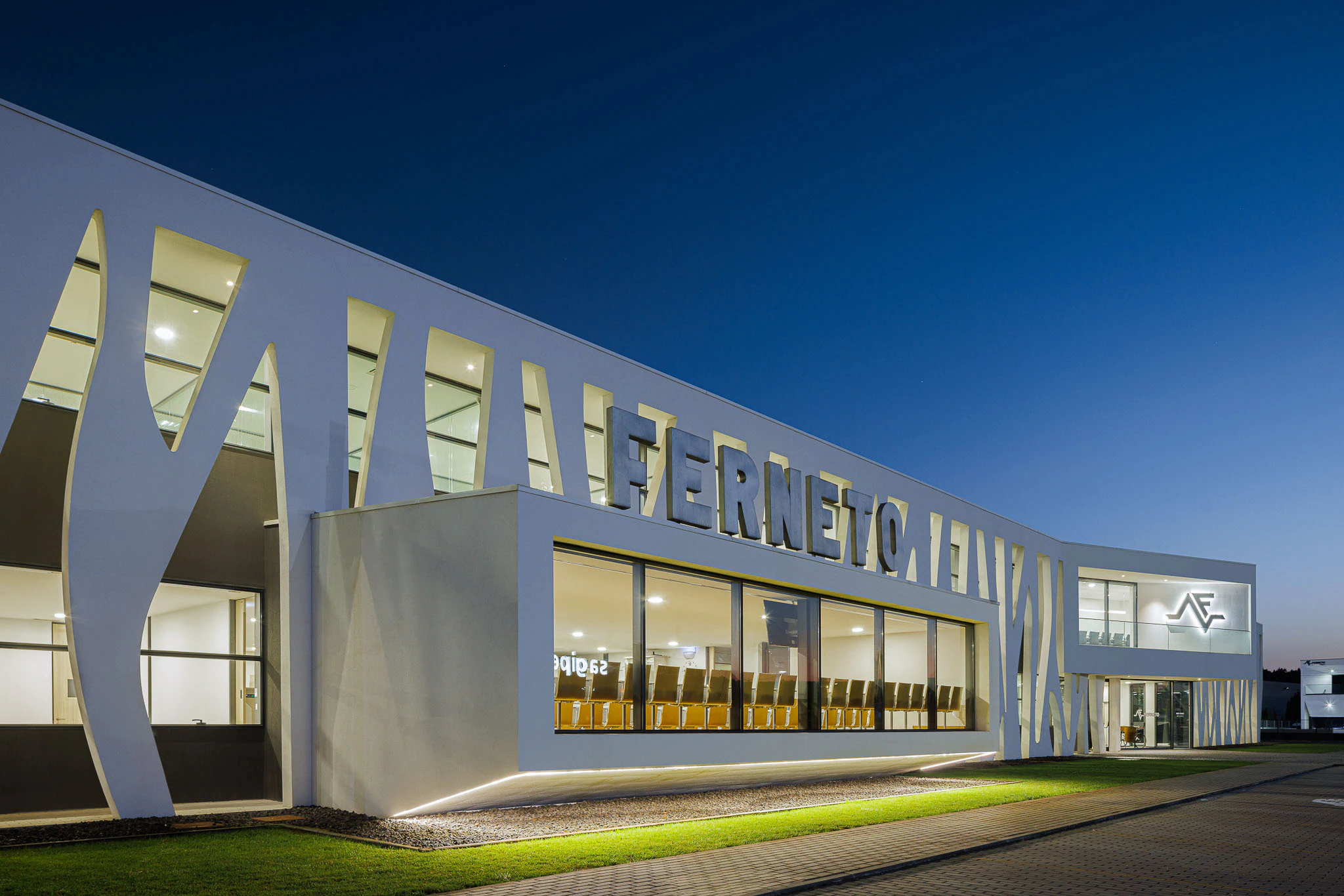 Exterior: Vista noturna do edifício com fachada orgânica, iluminação e céu estrelado. — Ferneto arquitetura Rómulo Neto Arquitectos em Vagos