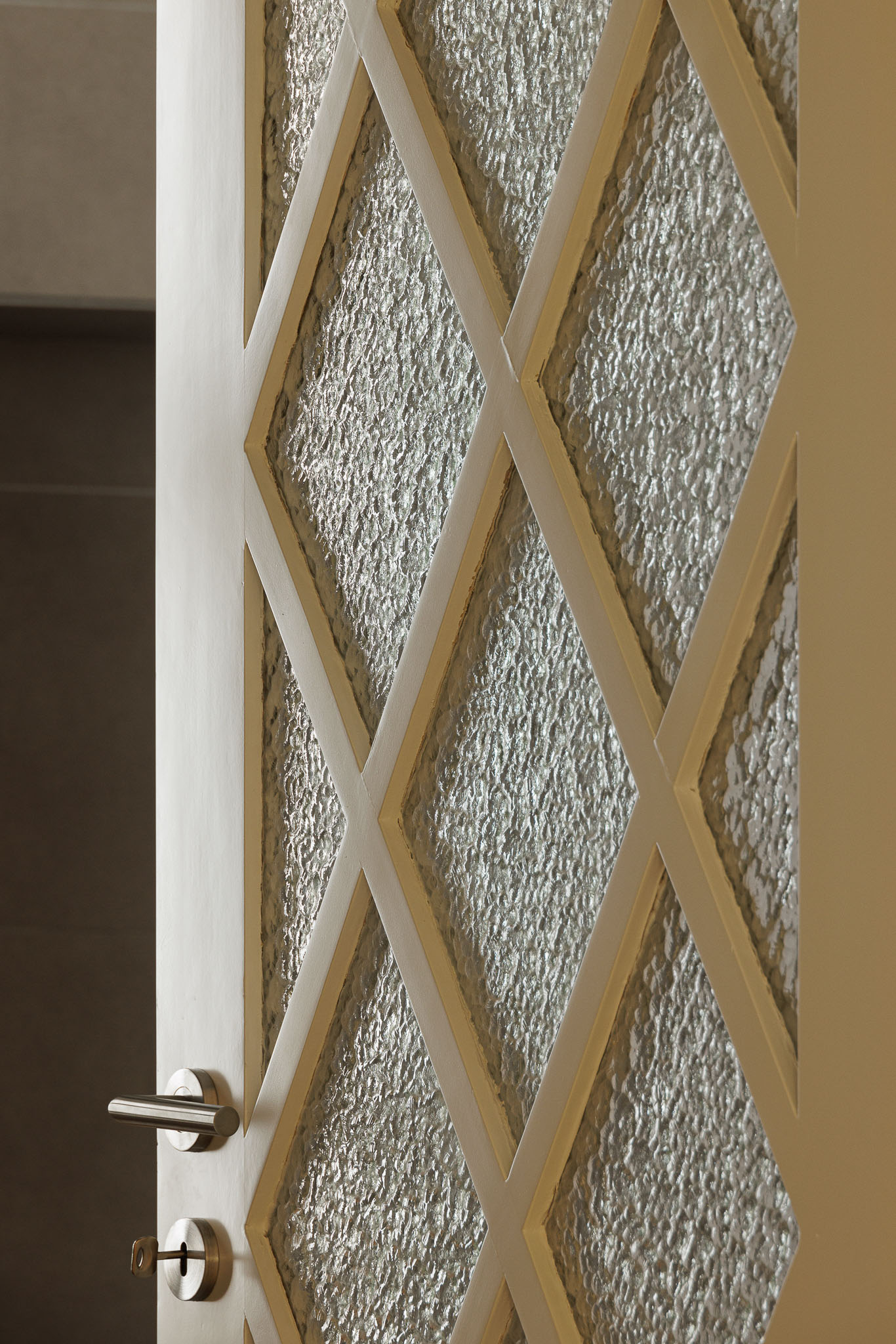 Detalhe: Close-up da porta com vidro texturado e padrão geométrico. — Casa dos anos 40 arquitetura Frari em Ílhavo